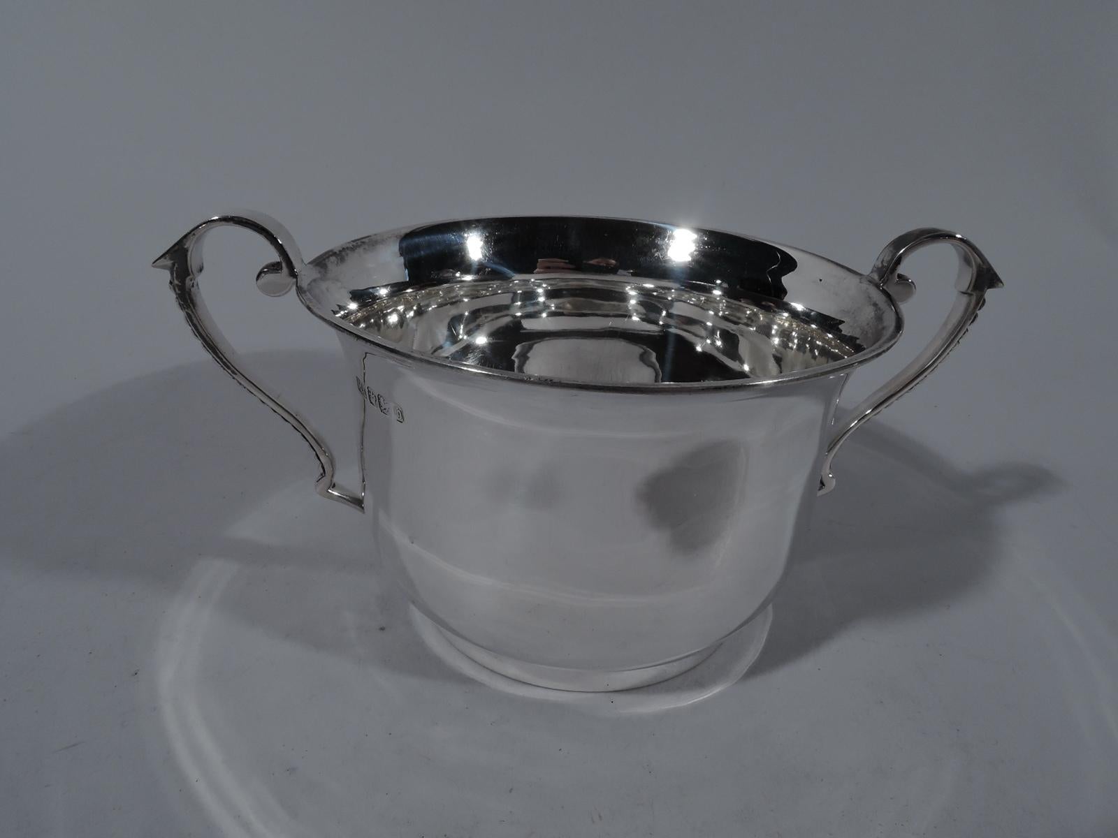 Victorian sterling silver two-handled cup. Made by Atkin Brothers in Sheffield in 1900. Curved bowl with flared rim and short and straight foot ring. Capped and high-looping side handles with graduated beading. A traditional form. Suitable for