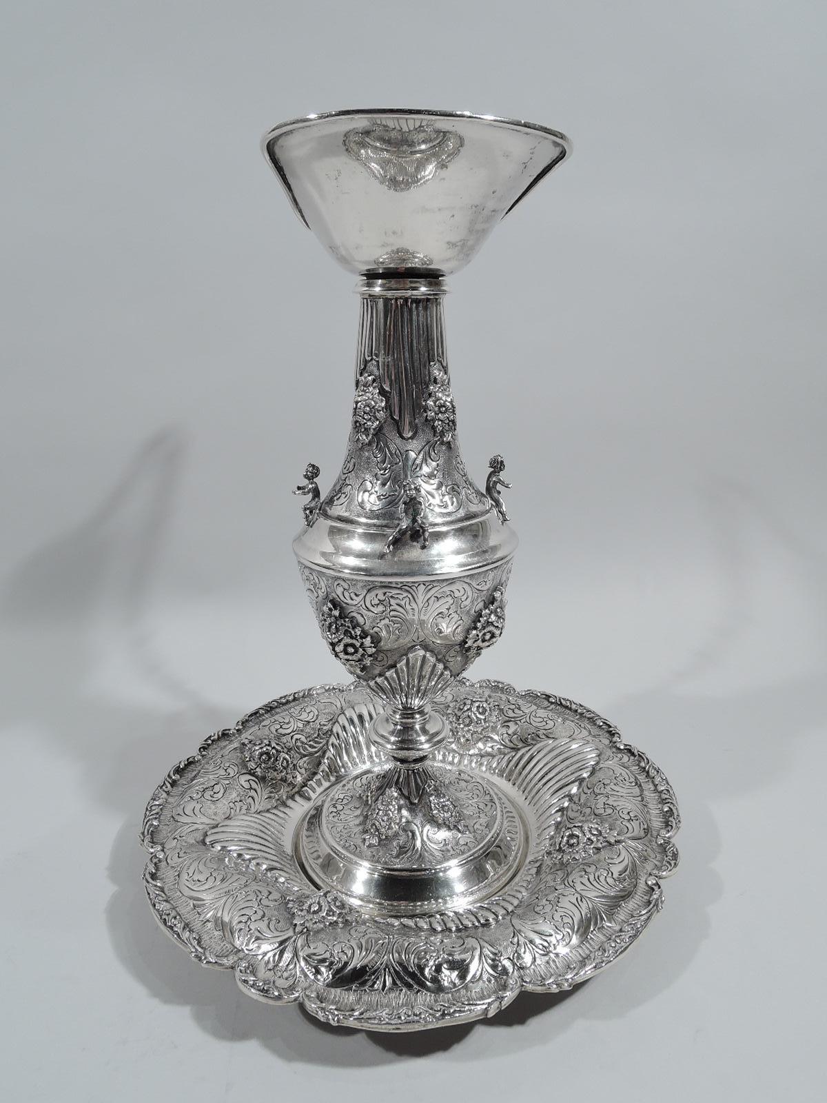 European Renaissance-style 800 silver wine ewer on stand. Ewer: Conical body, knopped support, raised foot with plain sides, upward tapering neck, and plain helmet mouth. Handle high-looping with scrolling leaves and animal-head mount. Stand: Plain