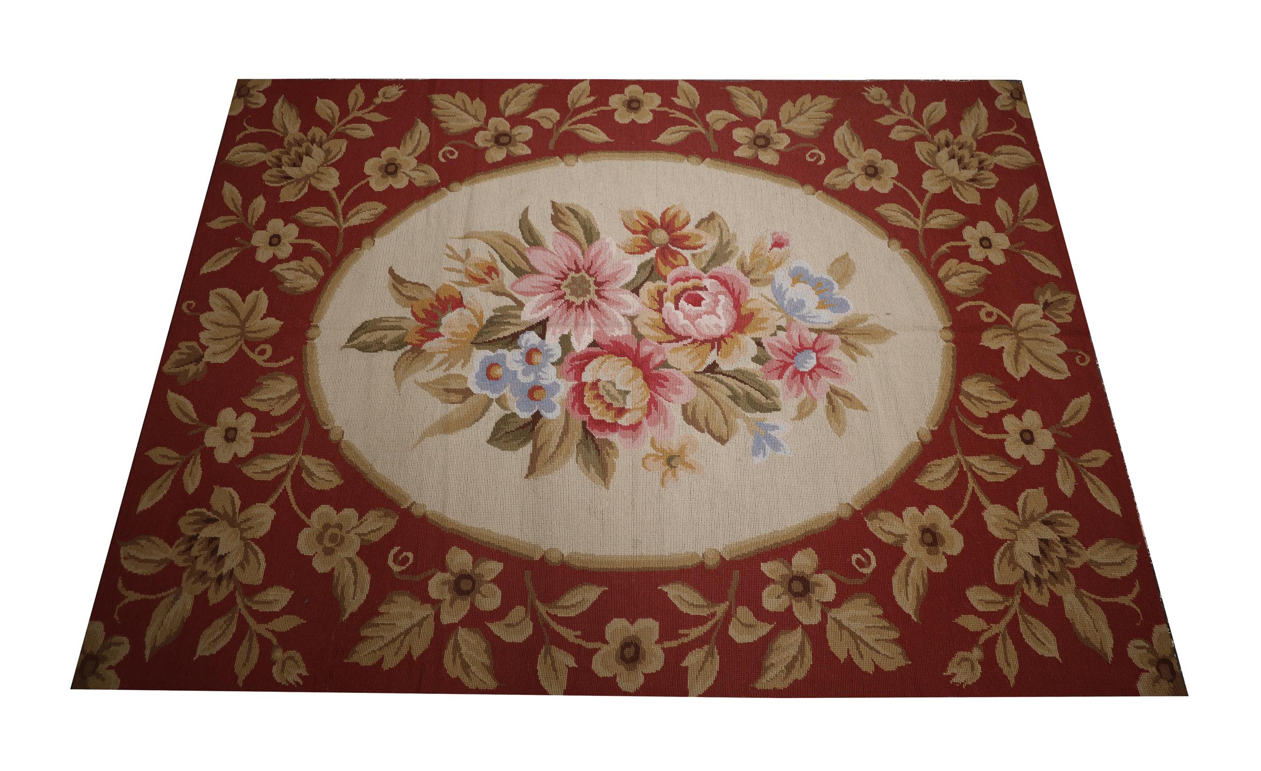 This New English Style Needlepoint was handwoven in the early 21st century and featured a traditional country house design with an oval central medallion and symmetrical surrounding design. Woven with an elegant colour palette of deep red, beige and