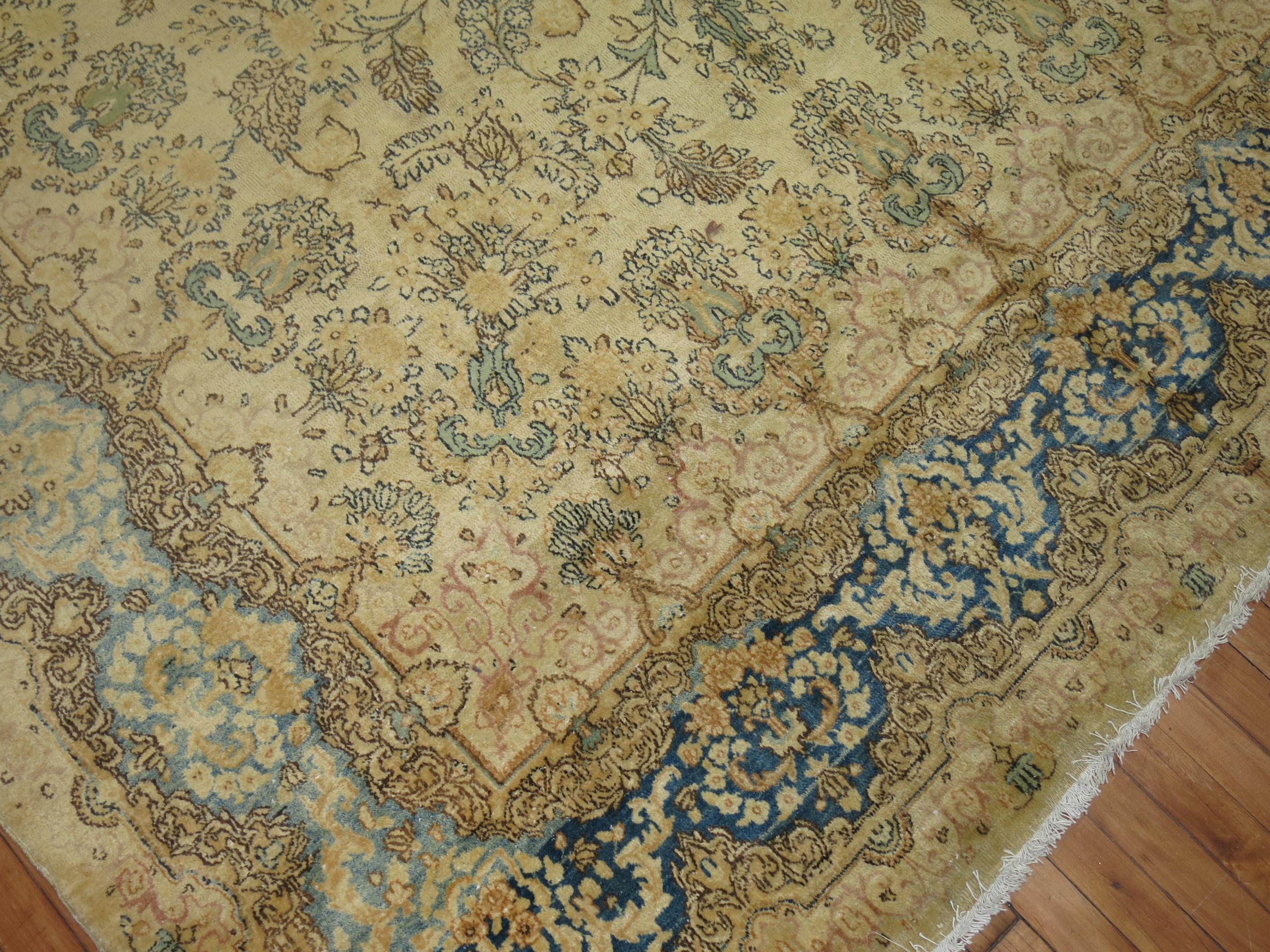 A 20th century room size Persian Kerman rug in beige, light blue, celery green, yellow and brown

Measures: 7'5'' x 10'2''.