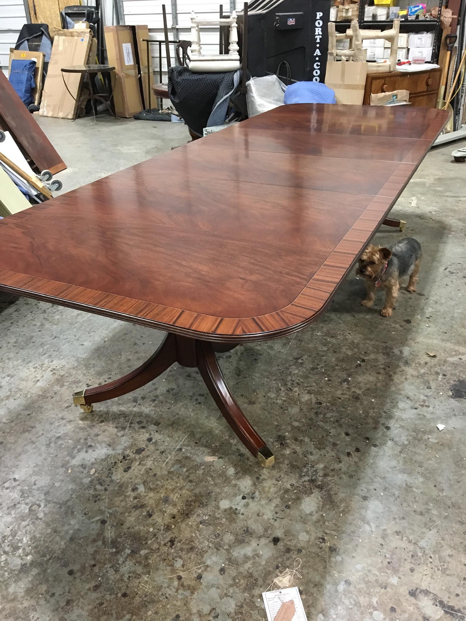 This is a made-to-order Traditional mahogany dining table made in the Leighton Hall shop. It features a field of slip-matched swirly crotch mahogany from west Africa and a Santos rosewood border from South America. It has a matte finish. The