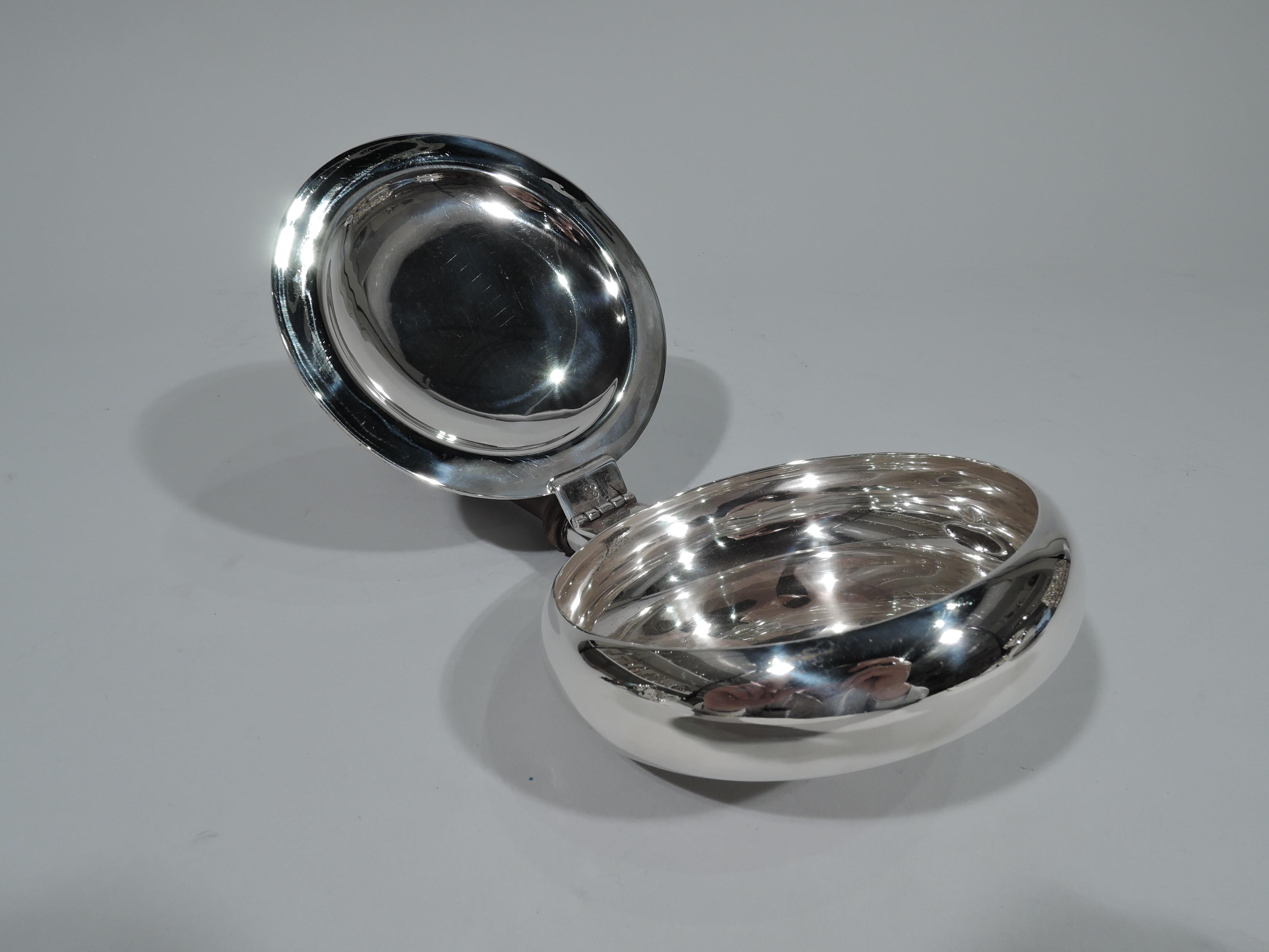 Traditional Georgian style sterling silver silent butler. Bellied bowl. Cover hinged with gadrooned rim and ornamental thumb rest. Tapering stained-wood handle. Mexican hallmark (1960s-1970s). Gross weight: 9 troy ounces.