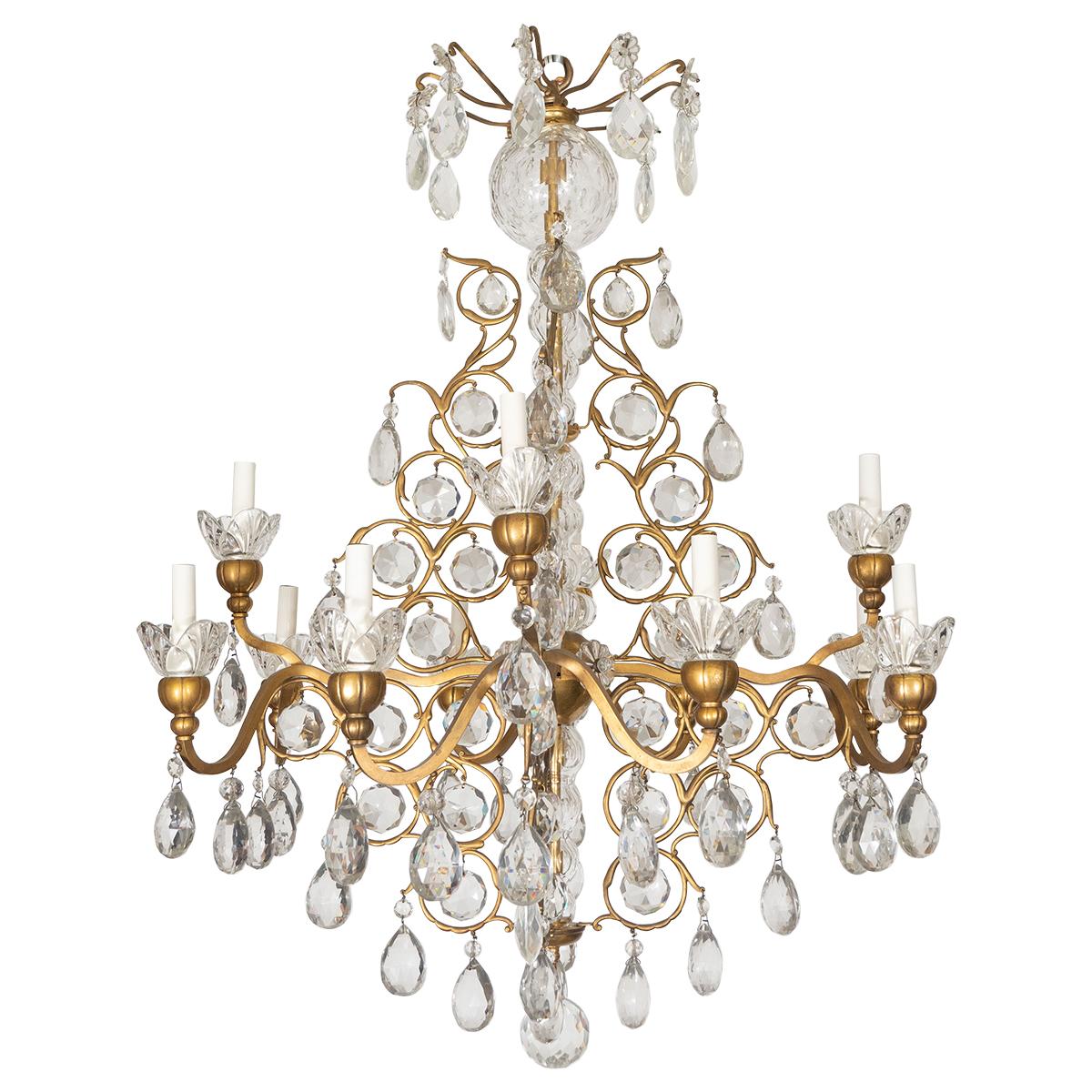 Traditional gilt metal chandelier with curvilinear tendril motif and crystal drop elements.