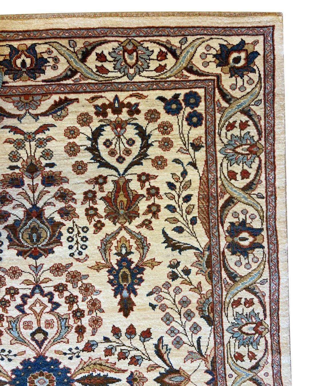 This traditional hand-knotted cream, blue, and red wool carpet, 5' x 7', is like a storybook garden woven in wool—where every vine curls with purpose and every bloom seems to hum with quiet beauty. A creamy backdrop sets the stage for intricate