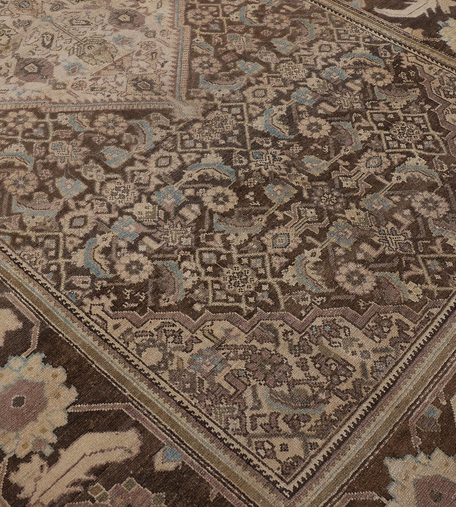 This traditional hand-woven Persian Malayer rug has a shaded chocolate brown field of dense herati pattern enclosing a serrated lozenge medallion enclosing an ornate flowering vase, in similar stepped herati spandrels, in a complementary palmette