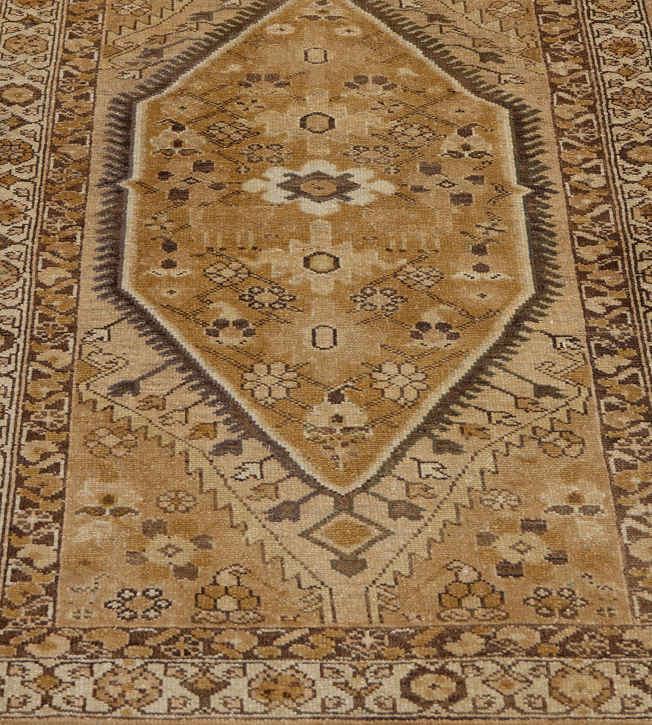 Dieser traditionelle, handgewebte persische Malayer-Teppich hat ein karamellbraunes Feld mit zarten Blumenmotiven um eine zentrale Säule aus miteinander verbundenen Rauten, die von einem zarten, maulwurfsbraunen, gezackten Band umgeben ist und