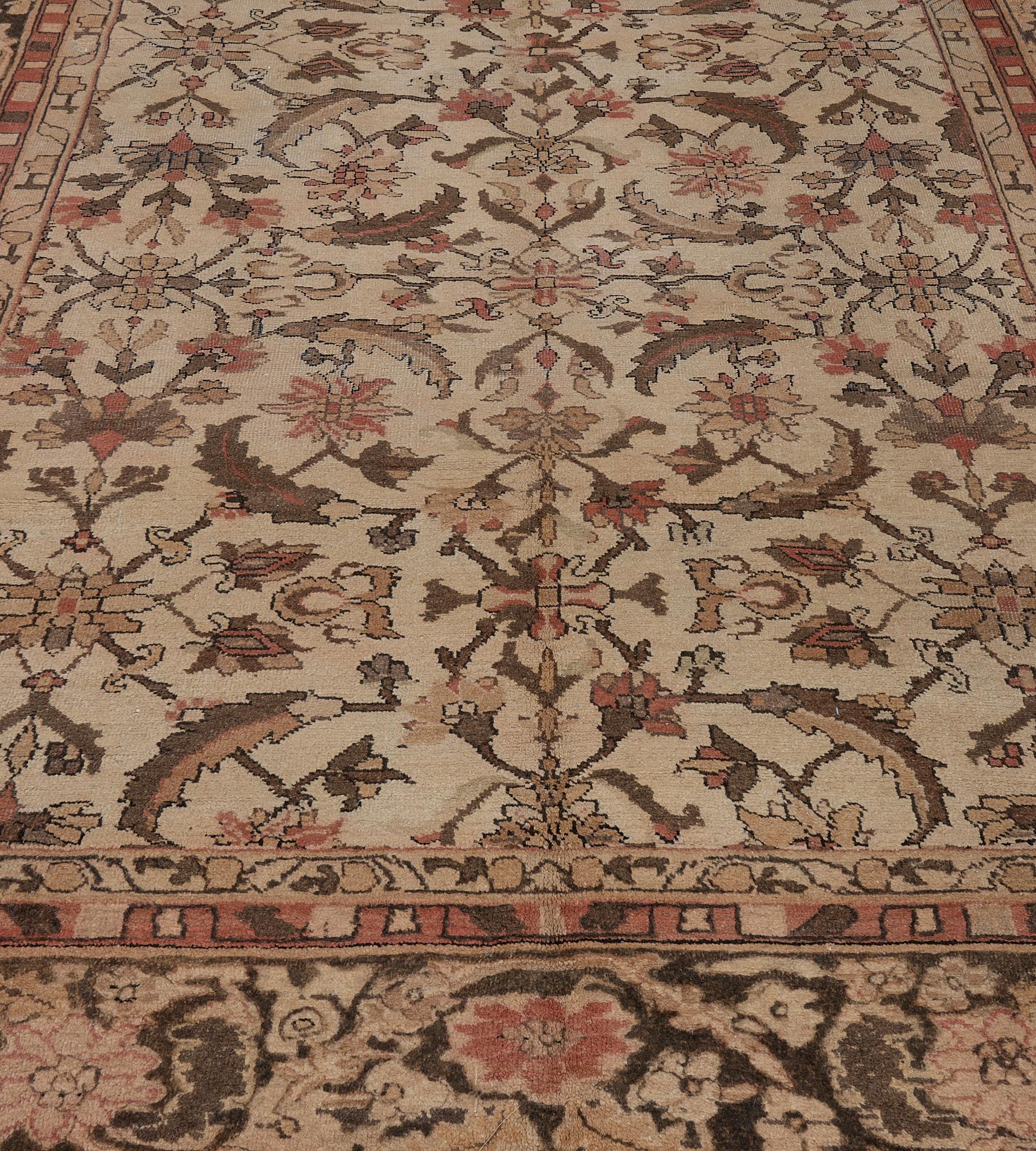 This traditional hand-woven Indian Amritsar rug has an ivory field with overall majestic herati pattern, in a deep umber scrolling rosette vine border, between complementary geometric stripes.
