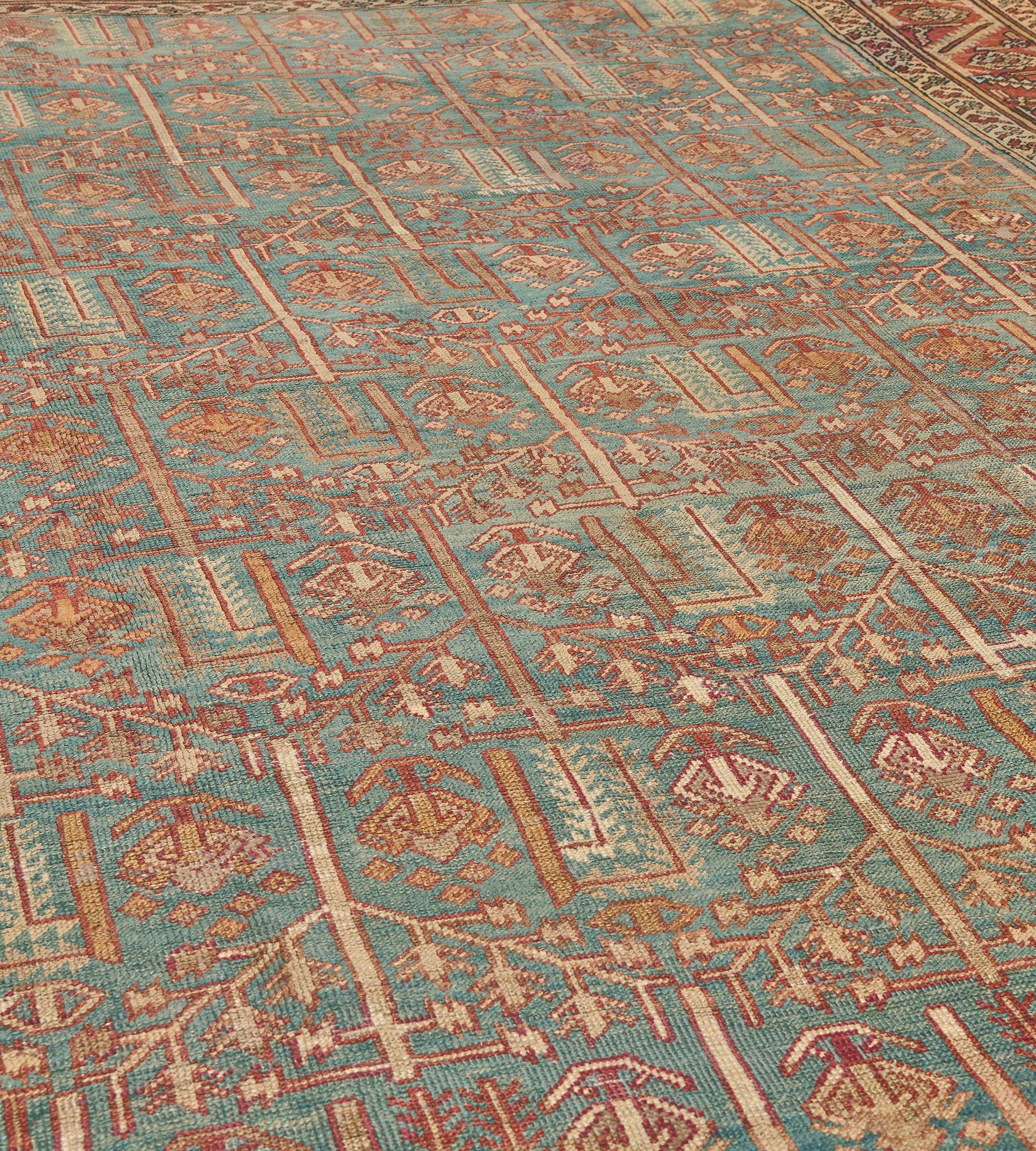 Dieser traditionelle handgewebte persische Bakhshaish-Teppich hat ein schattiertes hellblaues Feld mit einem Gesamtmuster aus Gitterranken, die Reihen von Rauten bilden, die jeweils vertikale stilisierte kleine Pflanzen um größere Palmetten und
