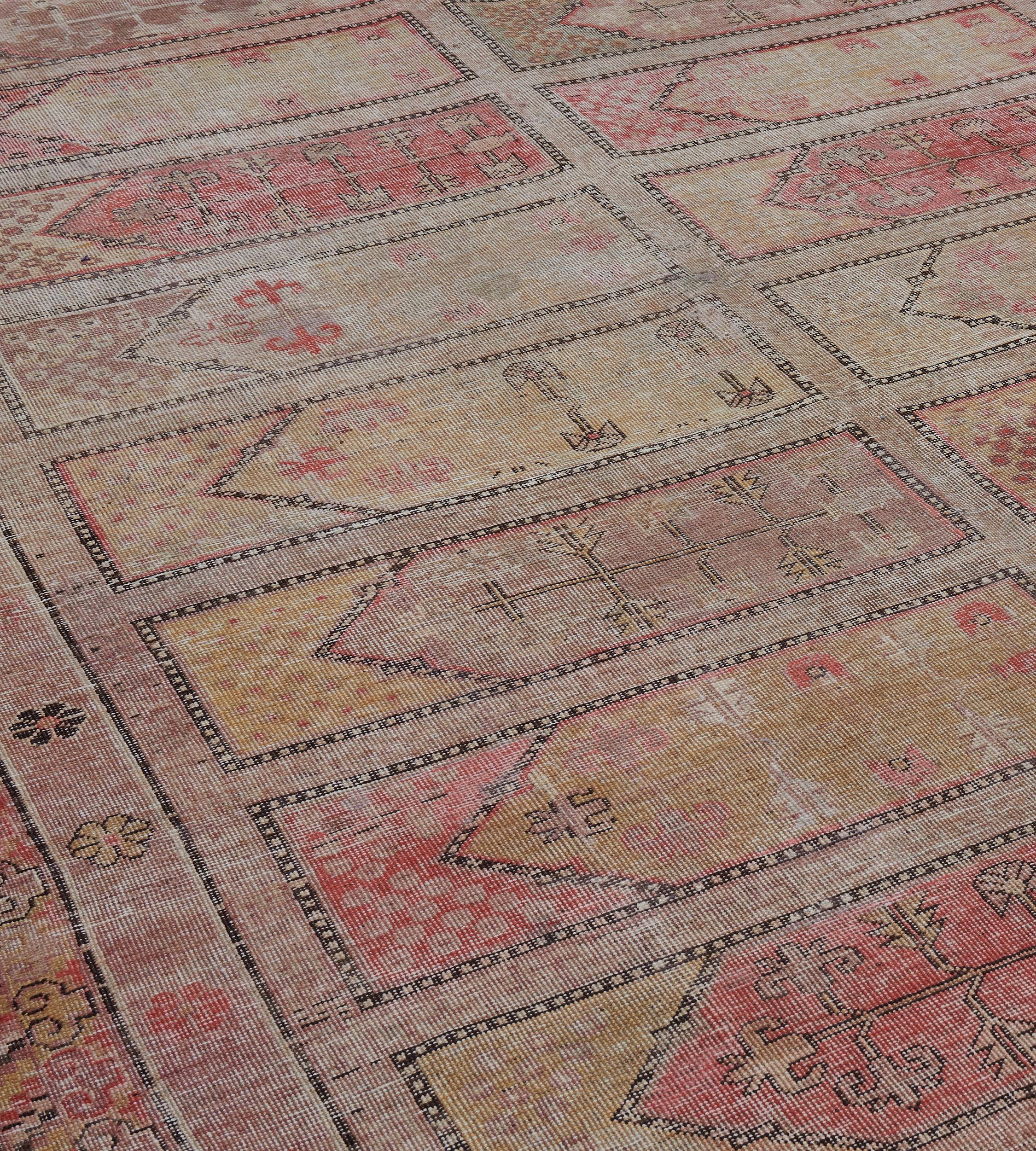 Dieser traditionelle, handgewebte Samarkand-Khotan-Teppich hat ein schattiertes, beigefarbenes Gebetsteppich-Feld, bei dem jedes Paneel eine blühende Vase in einer eleganten, traditionellen chinesischen Blumen- und geometrischen Bordüre einschließt.