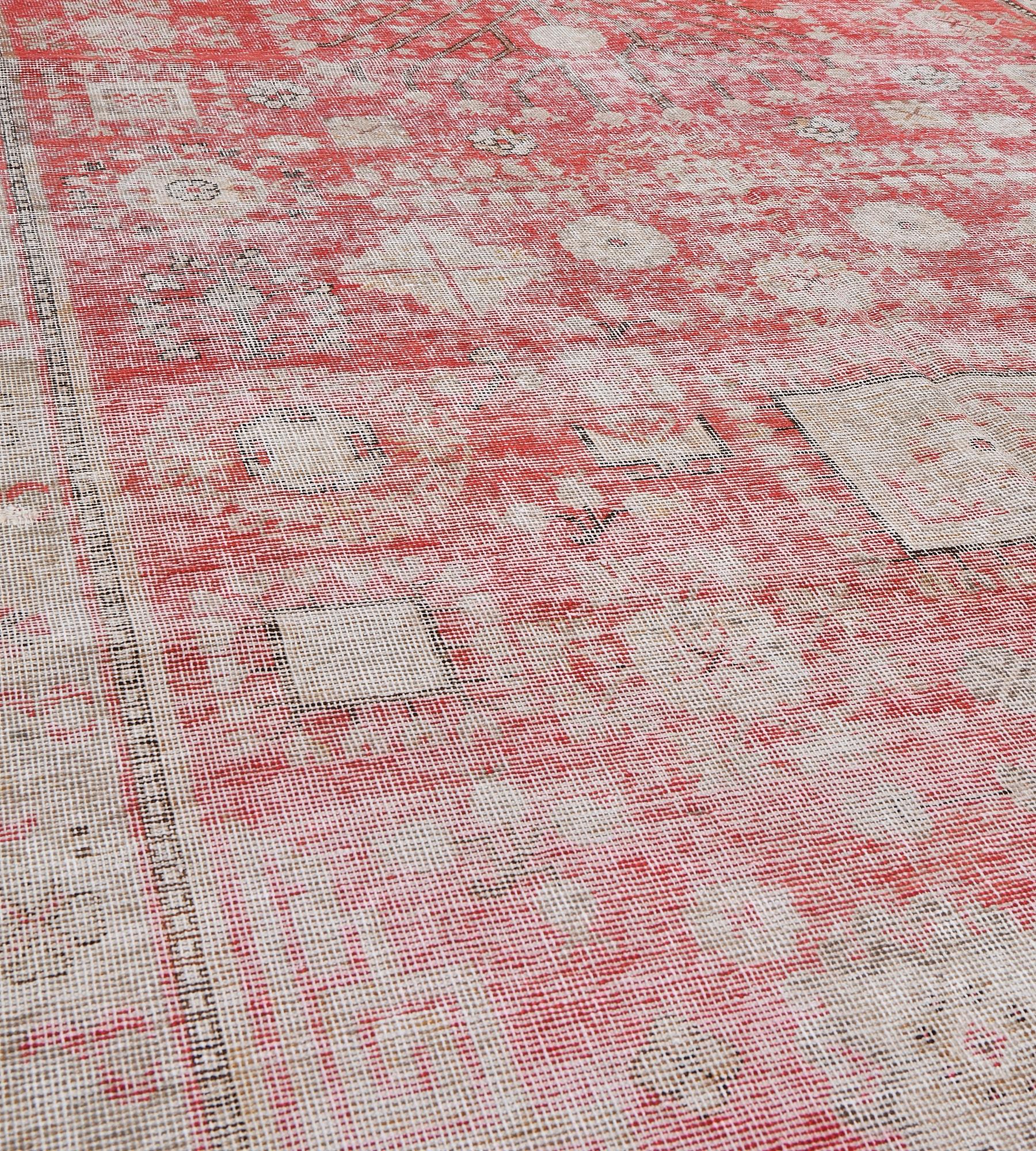 This traditional hand-woven Samarkand Khotan rug has a shaded rust red field of muted floral and geometric motif, with central pomegranate plant, in elegant tonal geometric borders