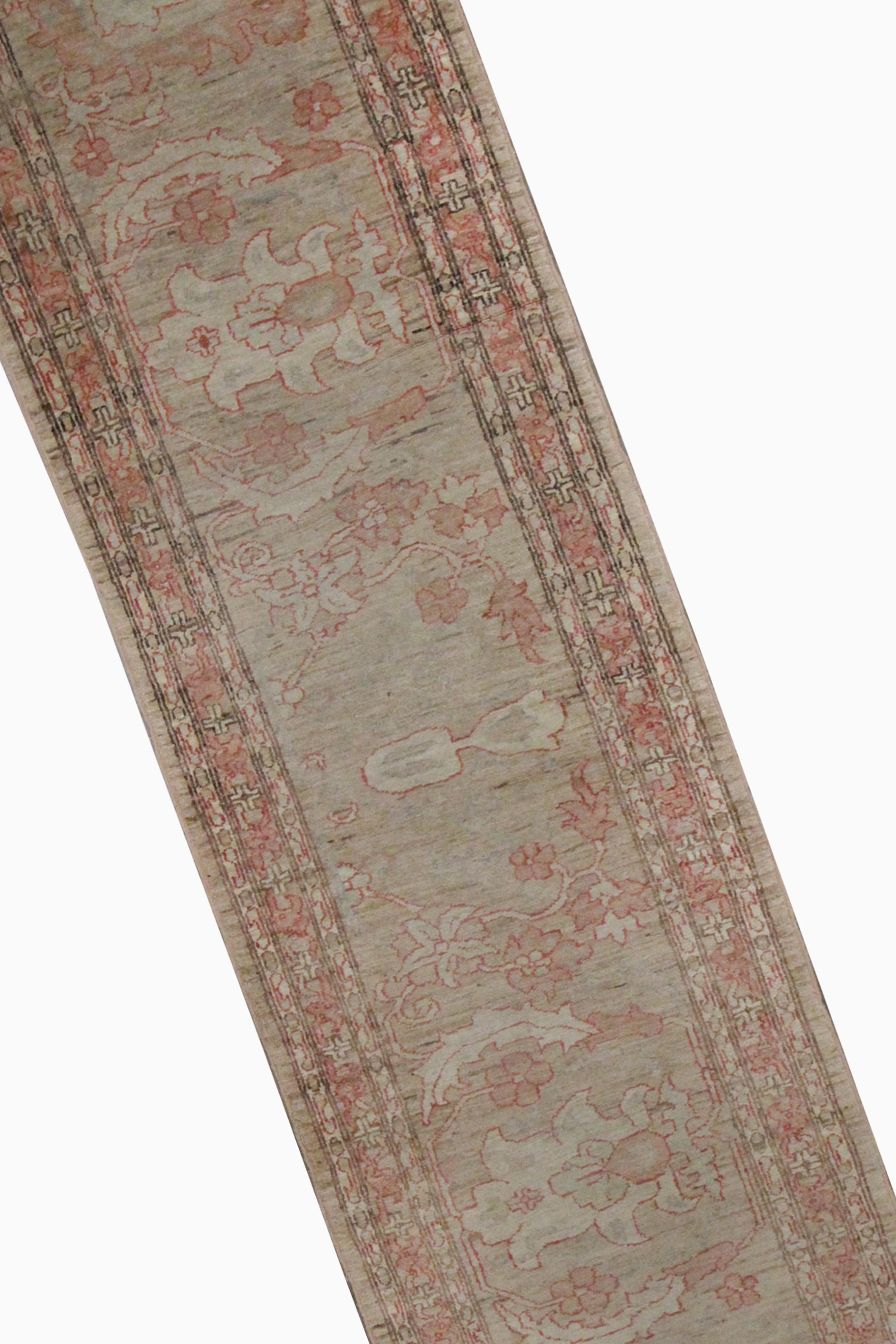 This beige runner rug is an excellent example of carpets woven by hand in the mid-20th century. The central design has been woven on a cream background with accents of pink that make up the decorative floral pattern. The delicate design and subtle