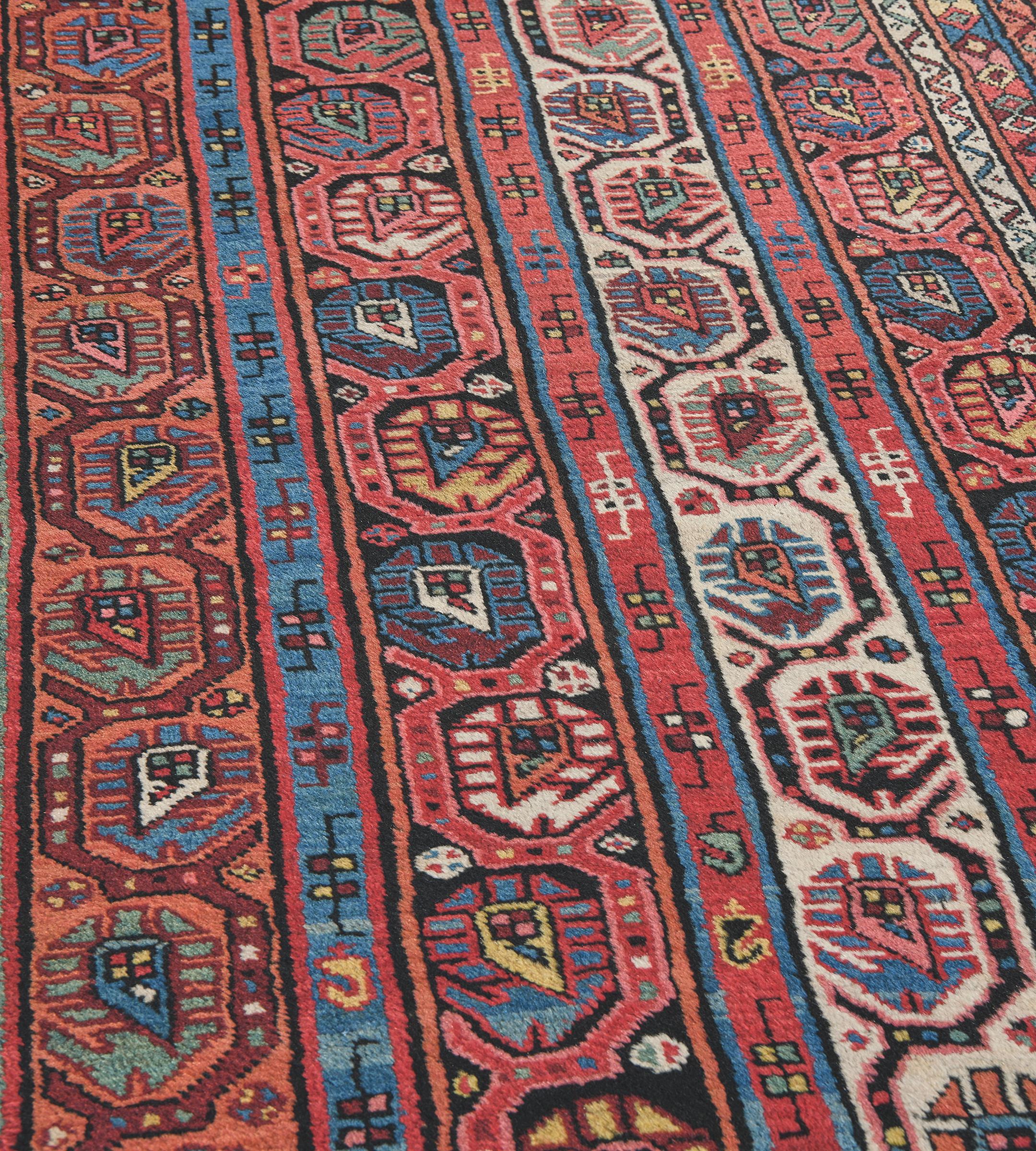Dieser traditionelle, handgewebte kaukasische Kurd-Kurah-Teppich hat ein schattiertes, ziegelrotes und elfenbeinfarbenes Feld mit vier geometrischen, stilisierten Paisley-Säulen, die durch innere, geometrische Paisley-Streifen in einer polychromen,