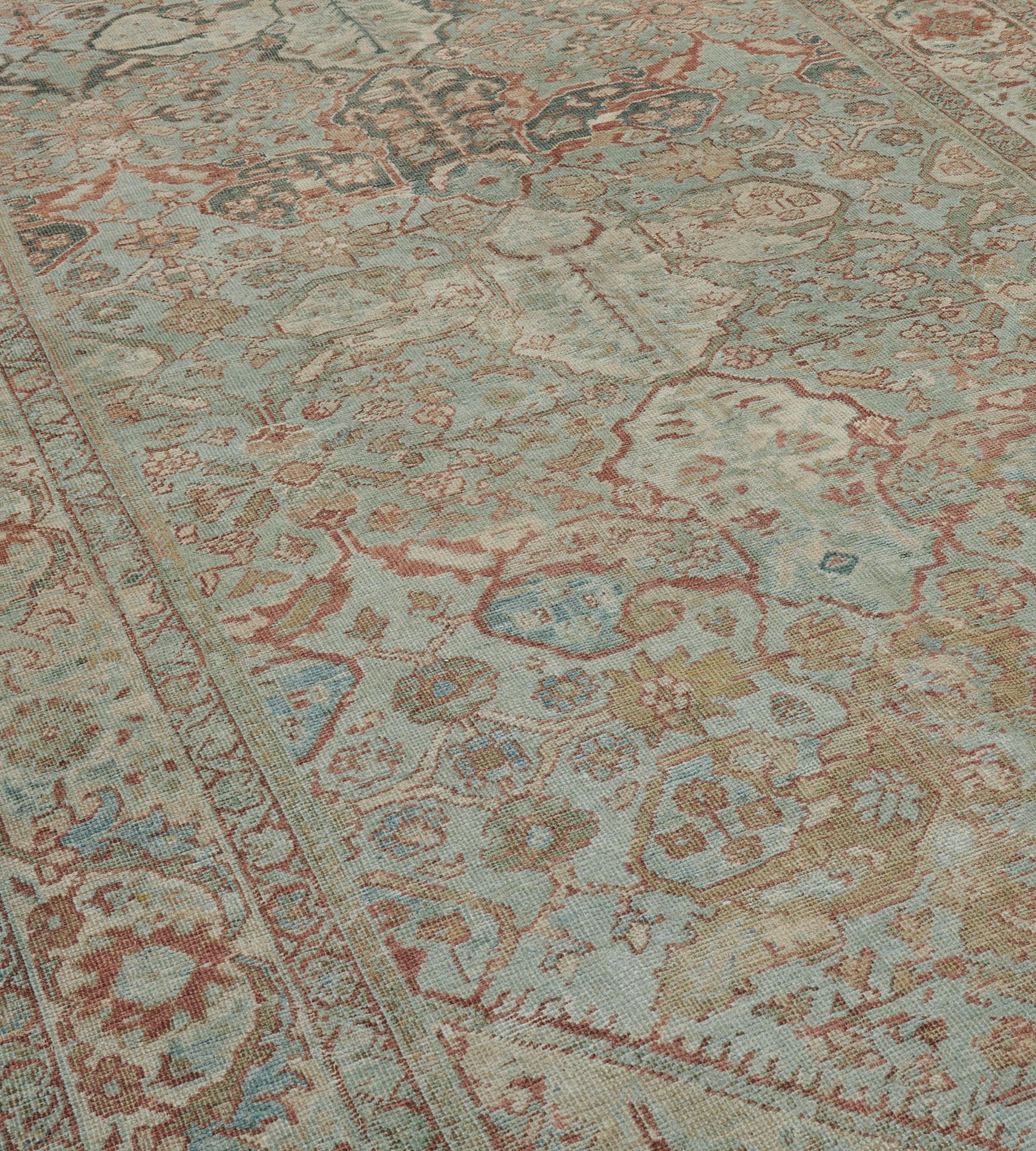 This traditional hand-woven Persian Sultanabad rug has a shaded pastel blue field of scrolling vines forming arabesque lozenge lattice, each enclosing tonal variations and fine floral motif, in a shaded pastel blue scrolling palmette border, between