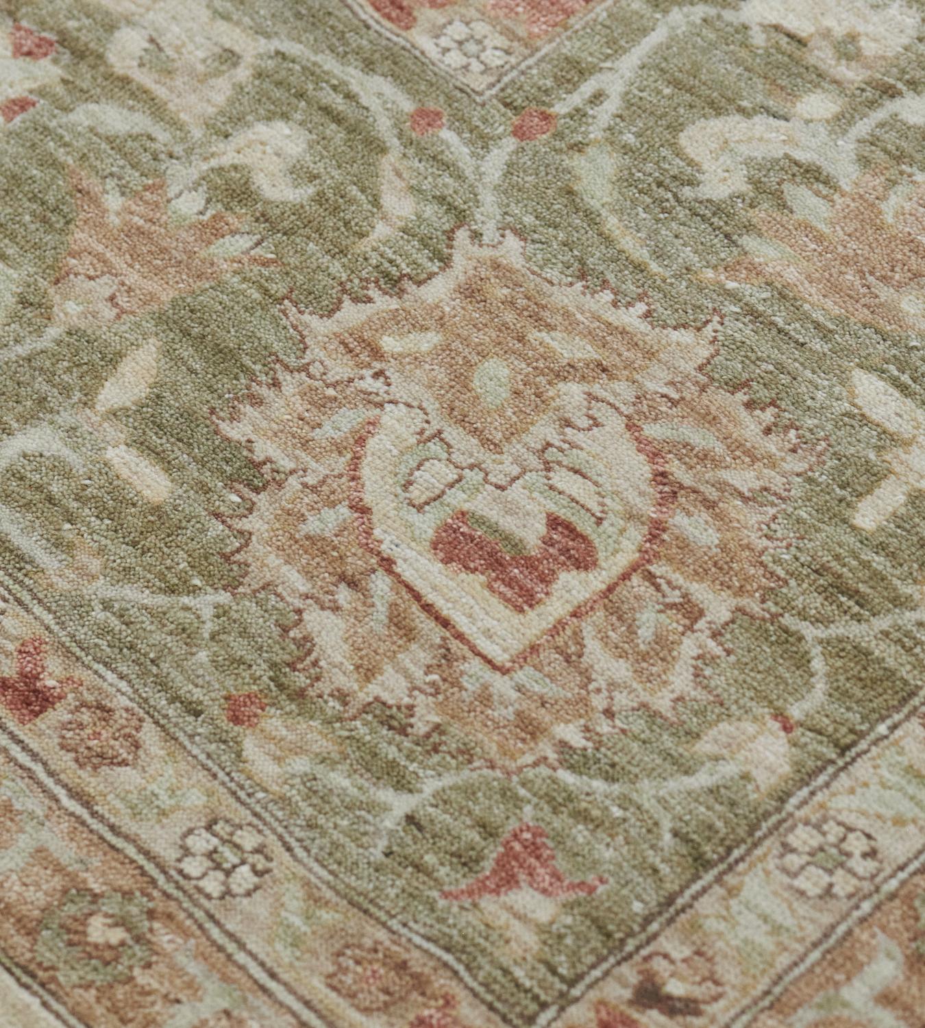 This revival Sultanabad has a shaded ivory field with an overall design of buff-brown, rust-brown, and shaded light green palmettes linked by delicate floral and leafy vine, in a shaded light green border of buff-brown, rust-brown and ivory