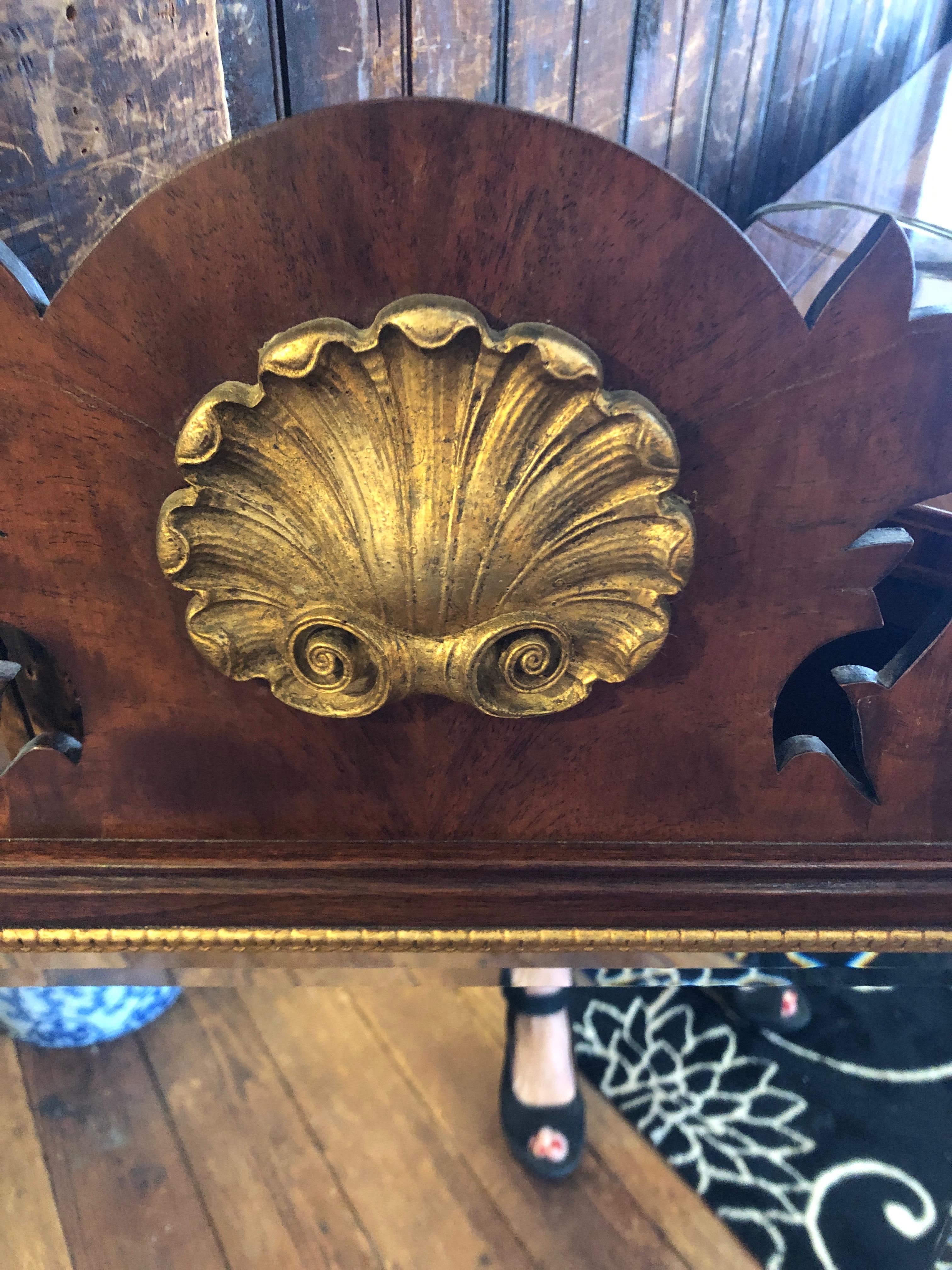 Handsome traditional vintage mahogany Henkel Harris mirror having neoclassical gilded shell at the top, gilded filet around the mirror, curlicues at the top and bottom and heavy bevelled mirror.