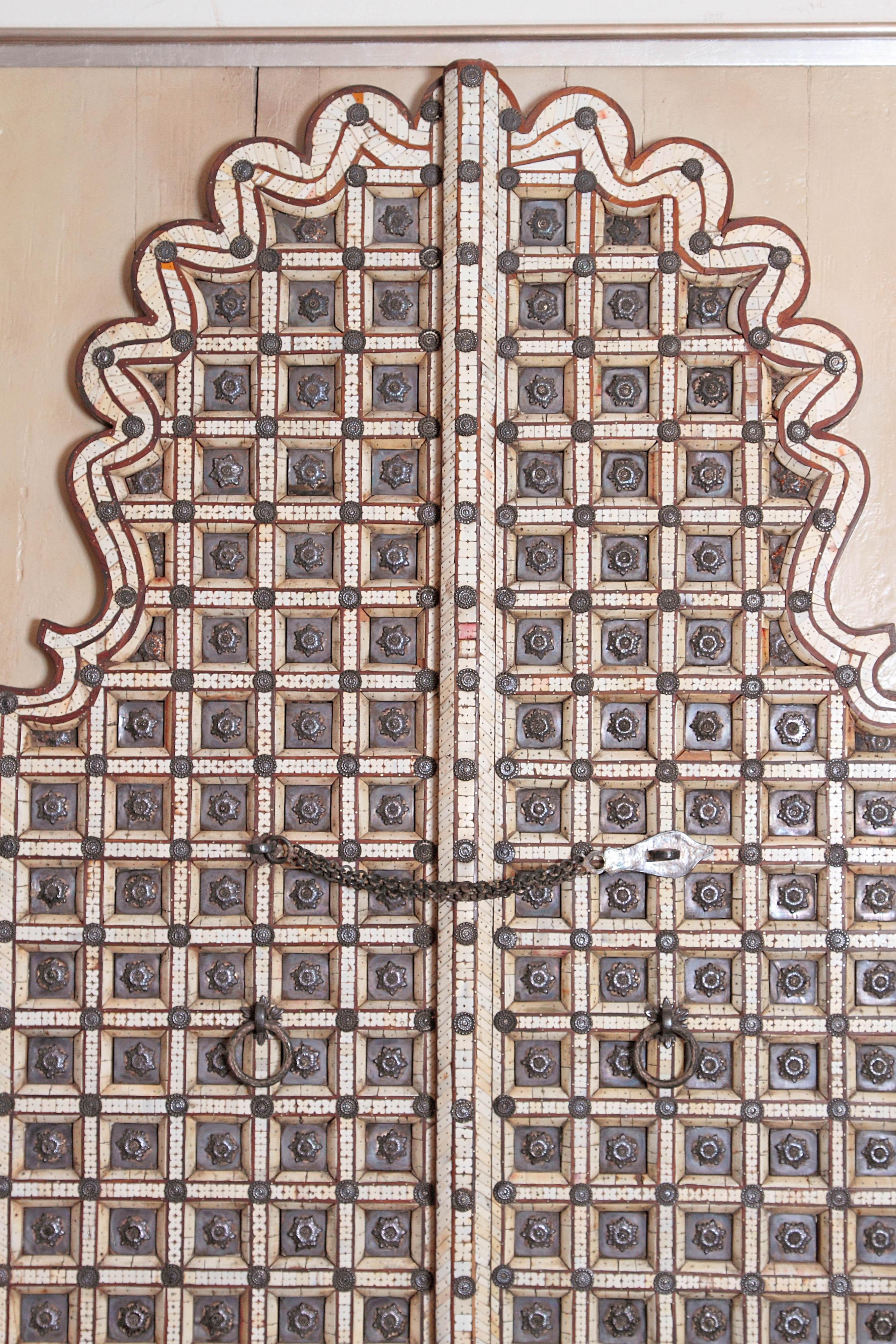 A pair of doors, mounted and framed for display. Overall small squares with carved florals. Interior with small squares trimmed in bone. Topped with rounded design, 19th century, India.