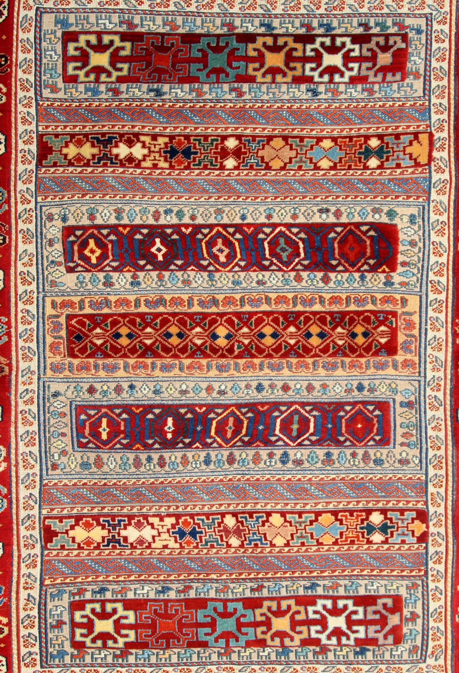 This unique kilim rug was woven by hand with the finest locally sourced hand-spun wool and cotton dyed with organic vegetable dyeing techniques. The design features a highly decorative stripe design with tribal motifs in orange, beige blue, and