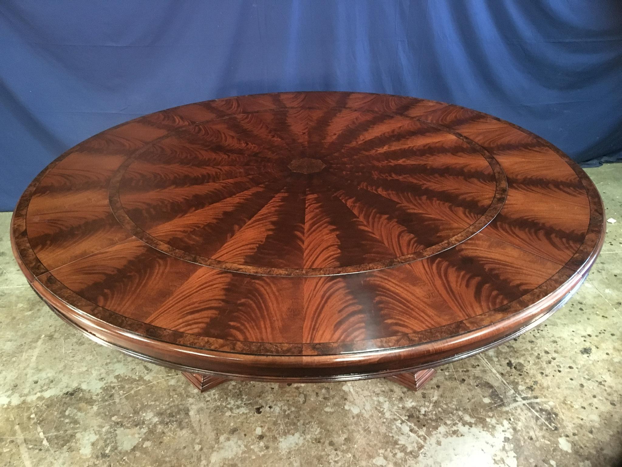 This is a made-to-order large round traditional mahogany dining table with perimeter leaves made by Leighton Hall. It is Leighton Hall’s largest round perimeter leaf table. It features a field of radial cut West African swirly crotch mahogany and