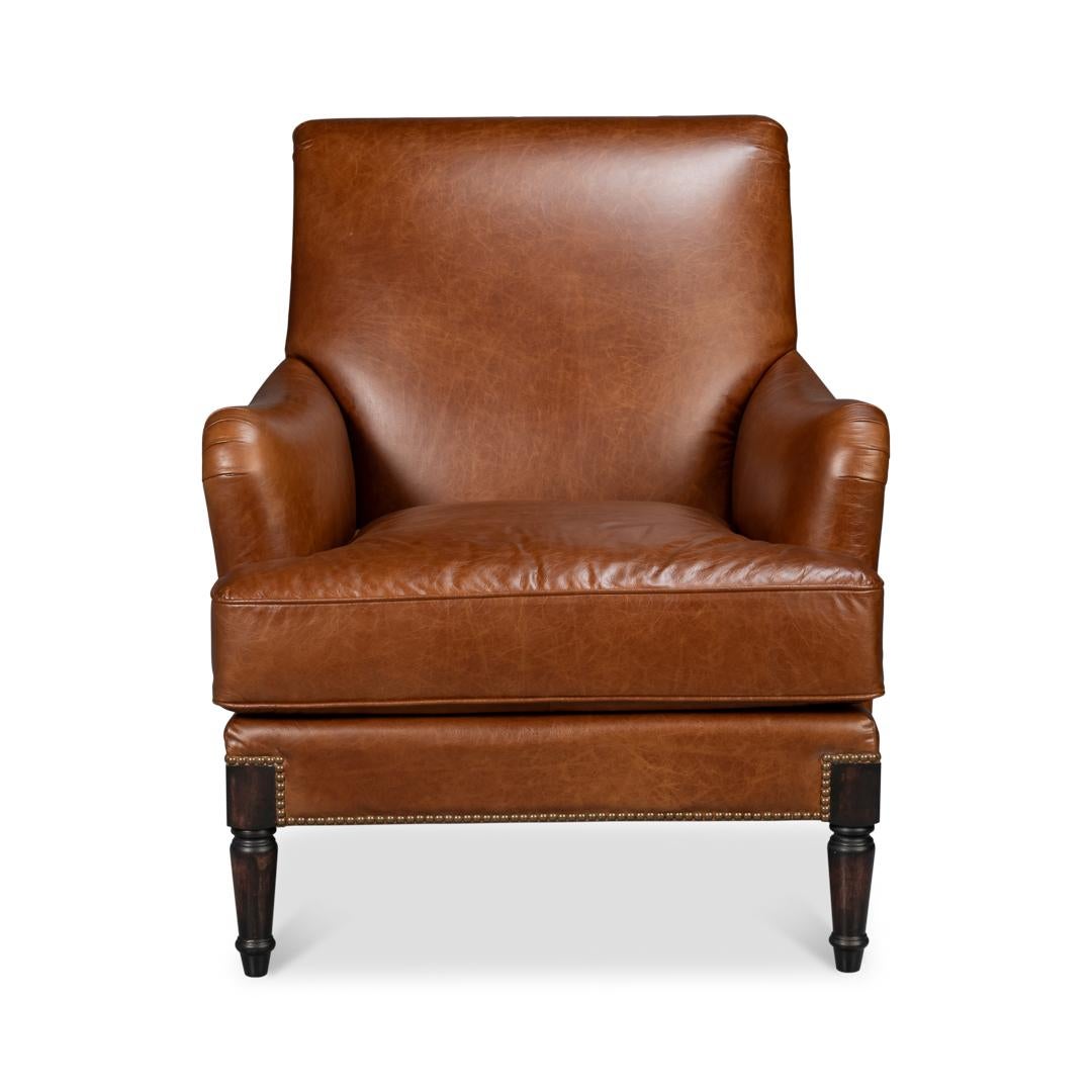 Upholstered in rich, full-grain havana brown leather, this chair exudes luxury while offering durability for years of use. The gently rolled back, curved arms, and detailed nailhead trim enhance its elegant design, making it a refined statement