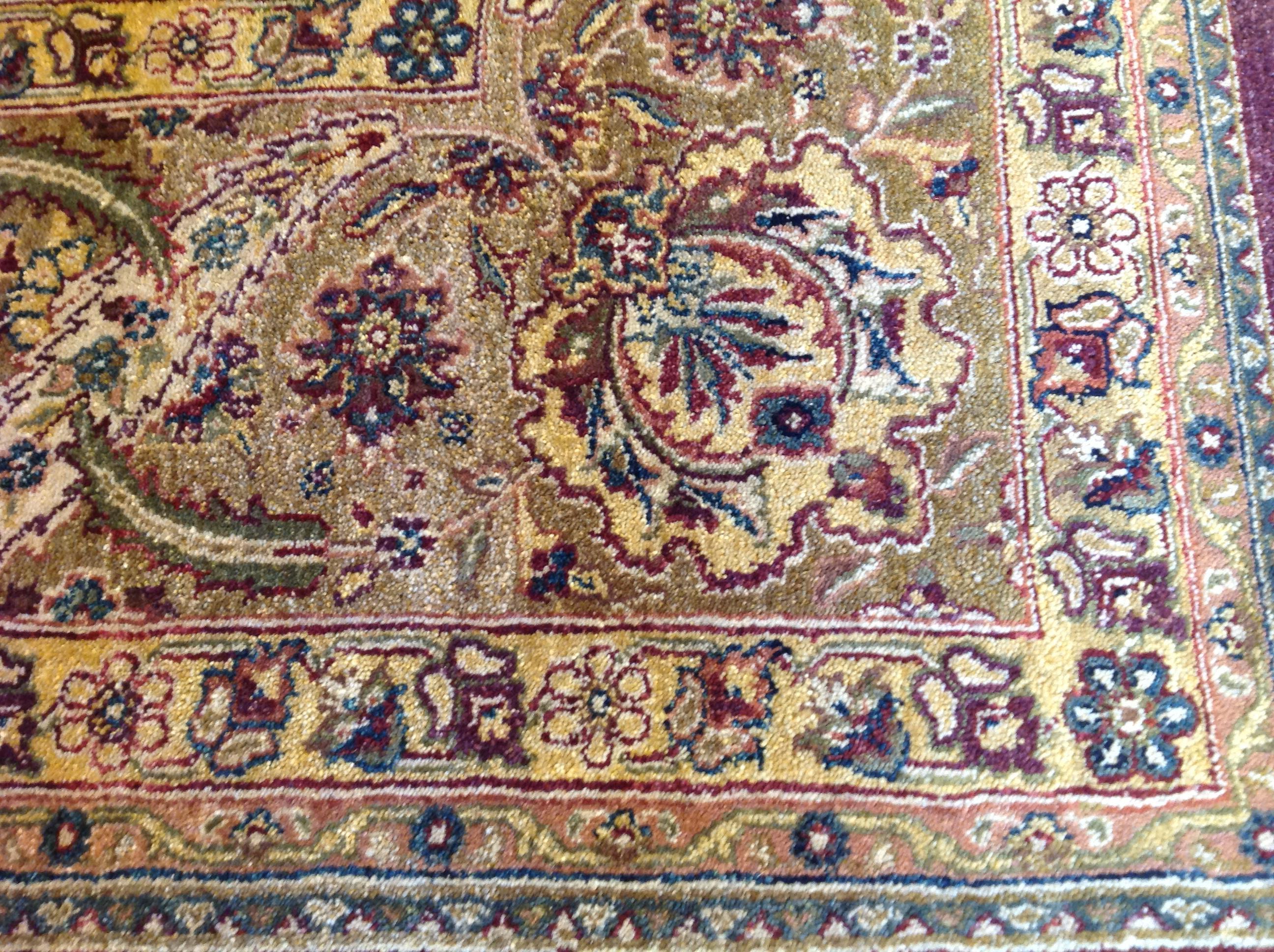 True to the highly decorative nature of the Mahal style, this elegant area rug features a sophisticated floral design against a burgundy center panel and light green and beige border. A sophisticated piece for home or office. Hand knotted in India.