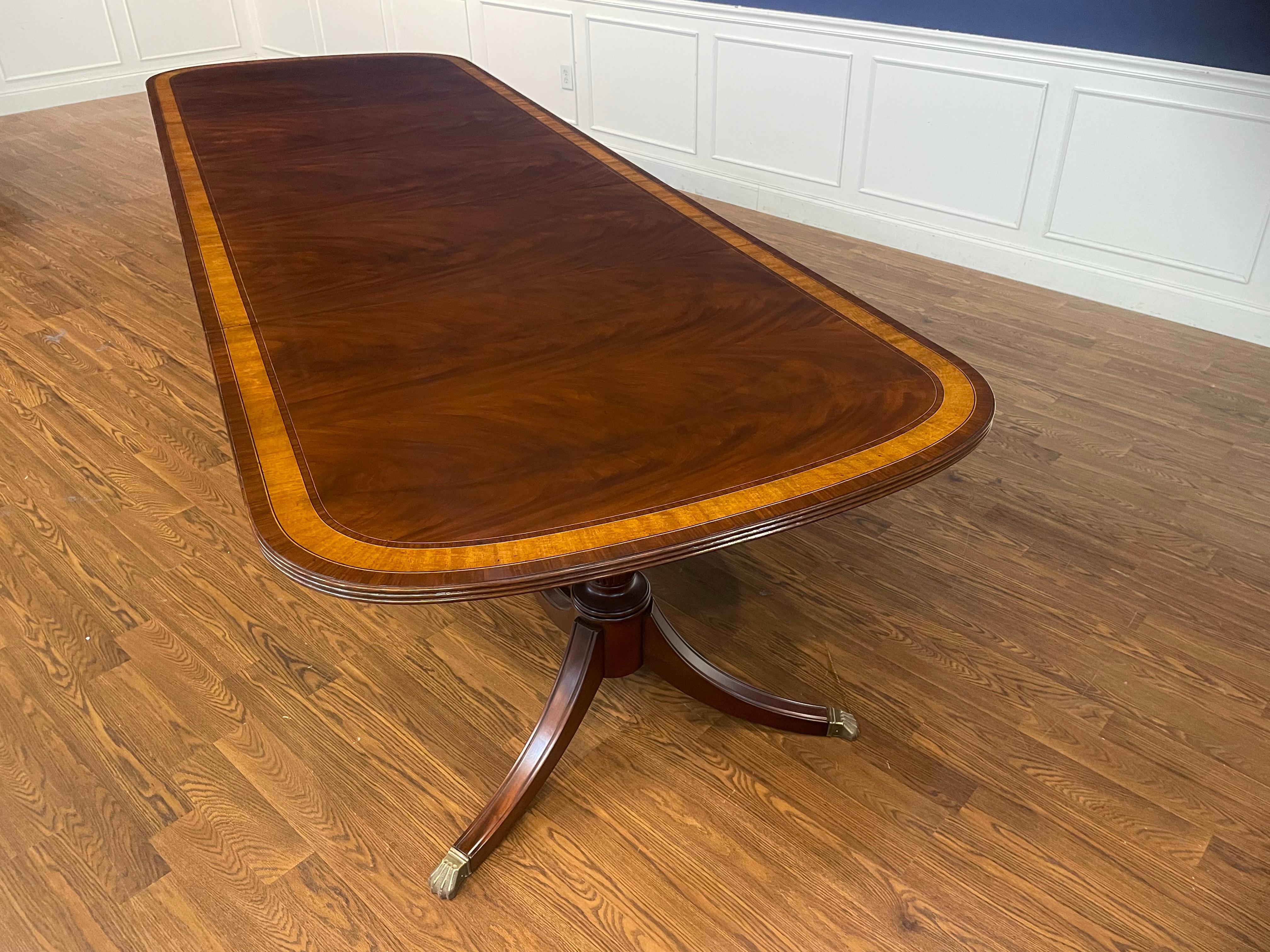 This is our traditional mahogany dining table. It features a field of slip-matched swirly crotch mahogany from West Africa and two borders of Pau Ferro and Satinwood. It has the optional hand steel wool rubbed satin finish. This finish is less