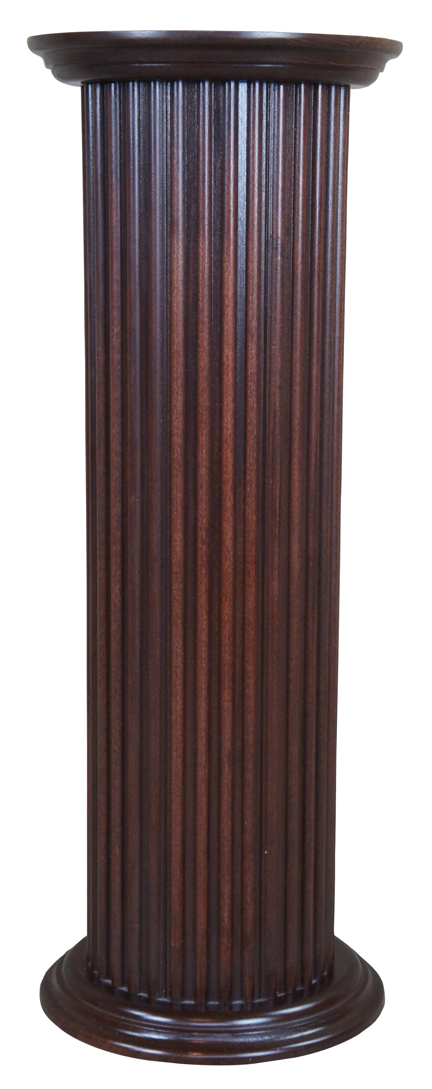 Vintage round pedestal or stand. Made of pine with a mahogany finish and reeded columns. Measures: 30”.
  