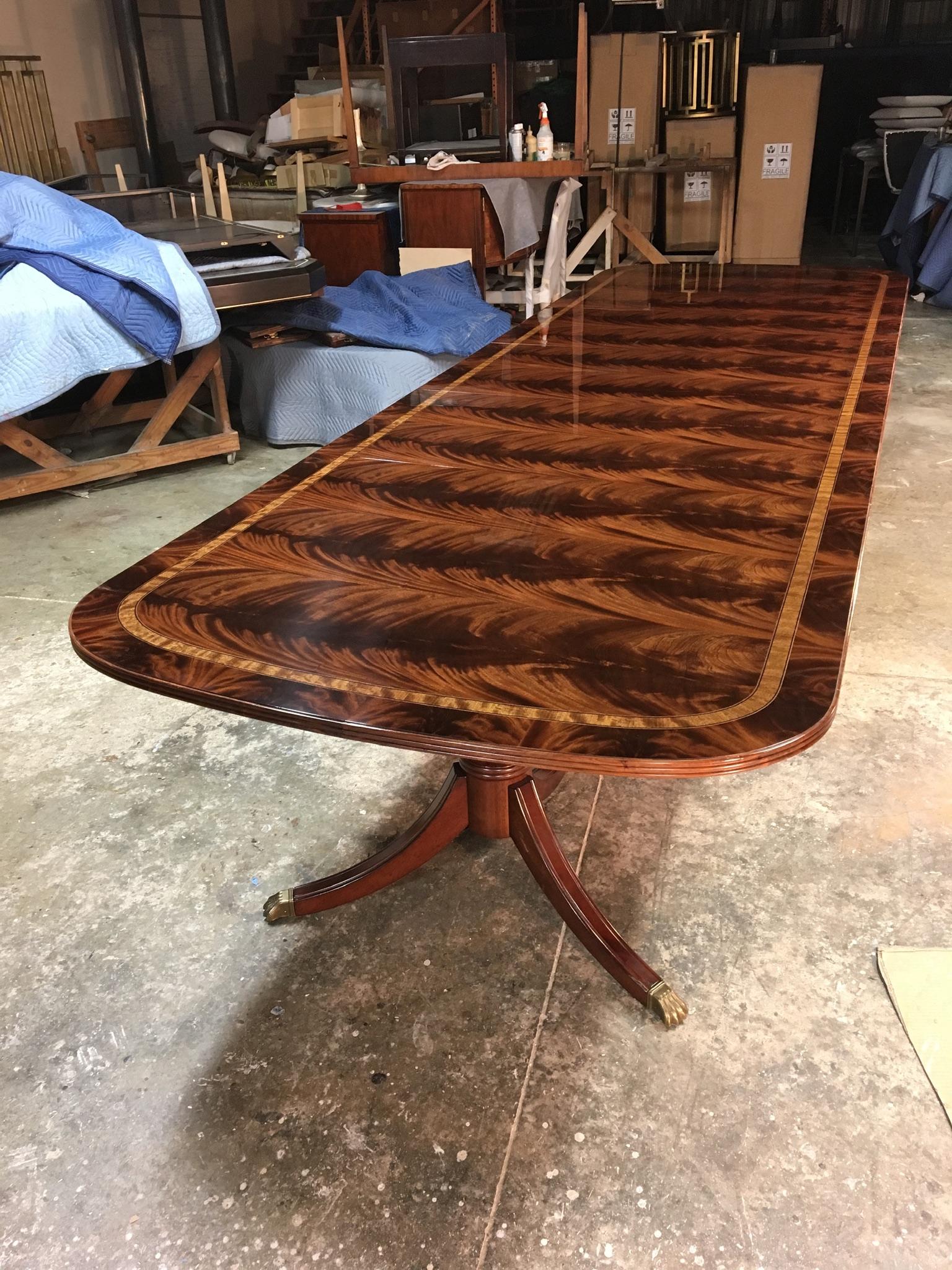 This is a made-to-order Large Traditional mahogany banquet/dining table made in the Leighton Hall shop. It features a field of slip-matched swirly crotch mahogany from west Africa with a satinwood inlay and a crotch mahogany border. It has a hand