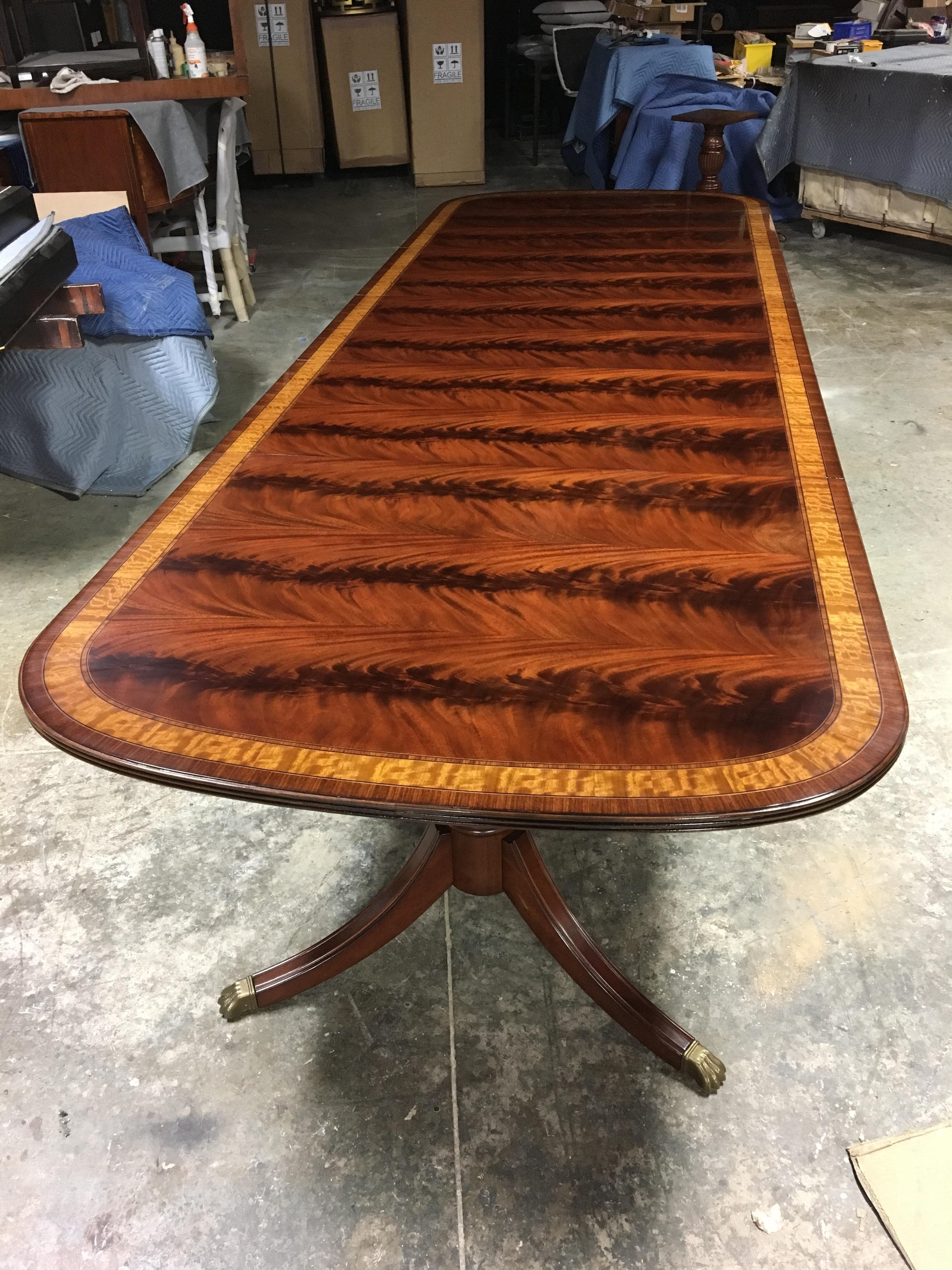 This is a made-to-order Large Traditional mahogany dining table made in the Leighton Hall shop. It features a field of slip-matched swirly crotch mahogany from West Africa and satinwood and santos rosewood borders from South America. The borders are