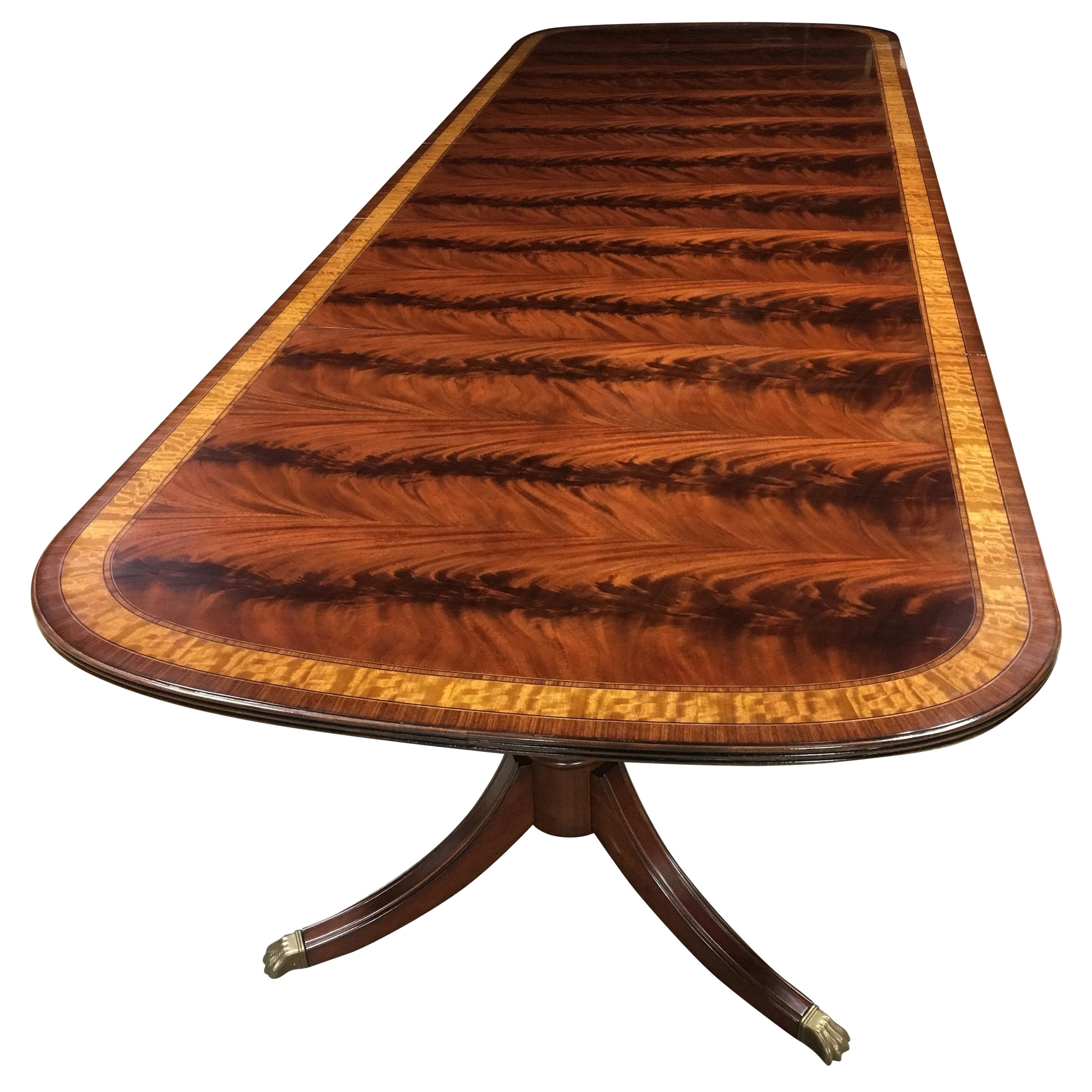 This is a made-to-order large traditional Mahogany dining table made in the Leighton Hall shop. It features a field of slip-matched swirly crotch mahogany from West Africa and Satinwood and Pau Ferro borders from South America. It has a hand rubbed