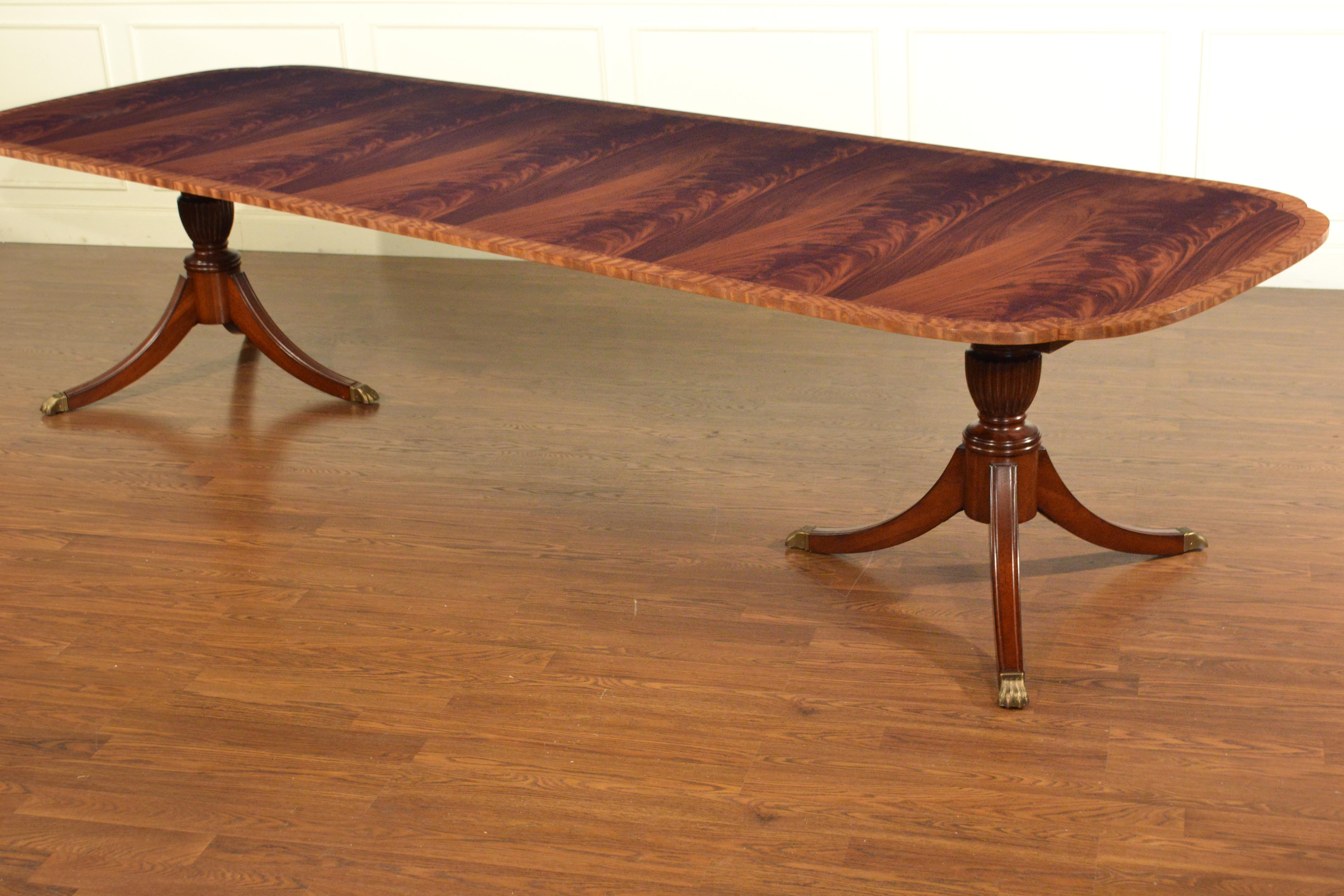 This is a made-to-order large traditional mahogany dining table made in the Leighton Hall shop. The highlight of this table is the elegantly shaped scalloped corners. It features a field of slip-matched swirly crotch mahogany from West Africa and a