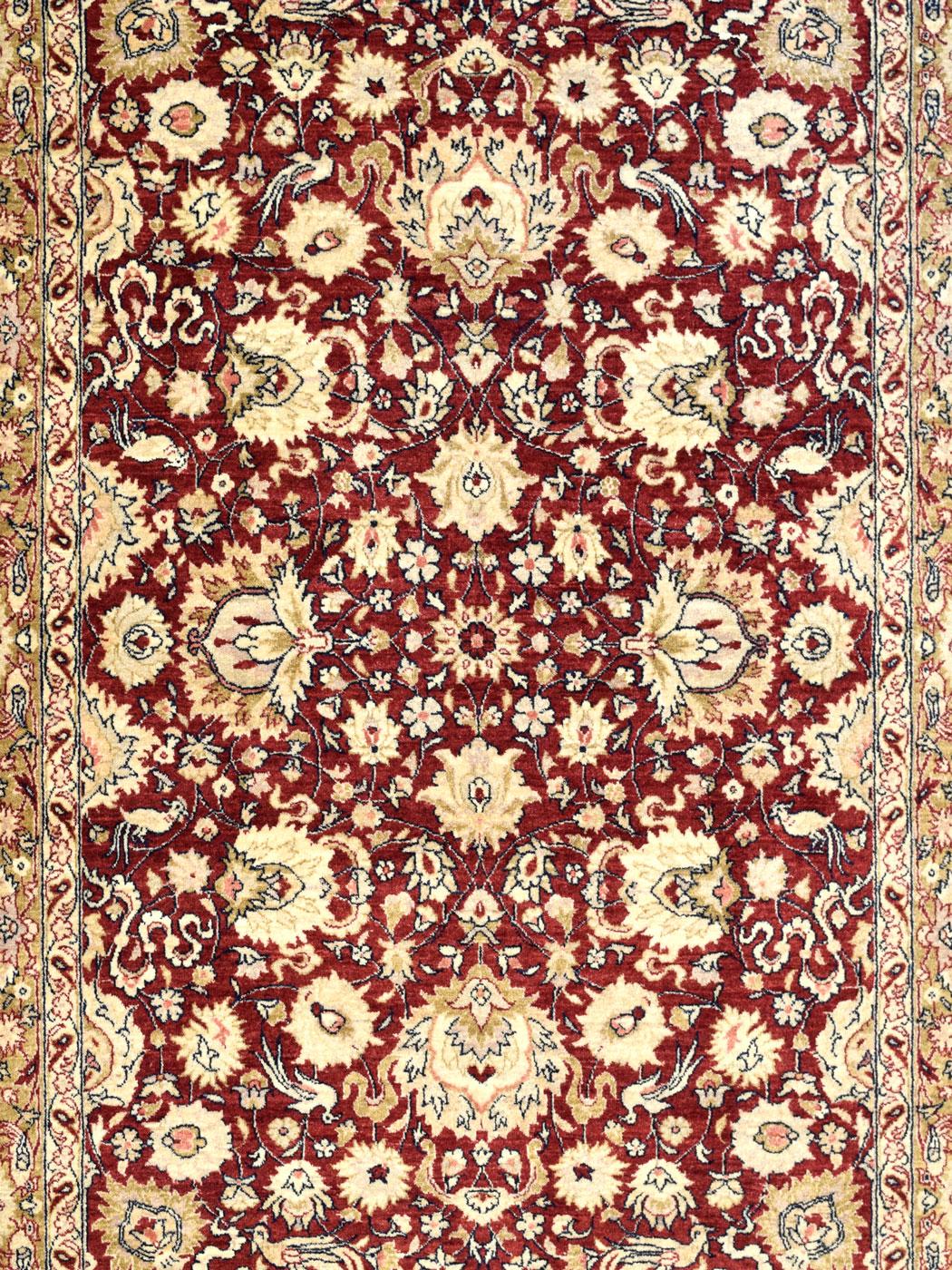 De riches tons de rouge, d'or et de crème évoquent l'élégance dans ce tapis persan en pure laine utilisant le tissage Mohtasham exquis d'Orley Shabahang dans une taille polyvalente de 5' x 7'. Mesurant exactement 5'2