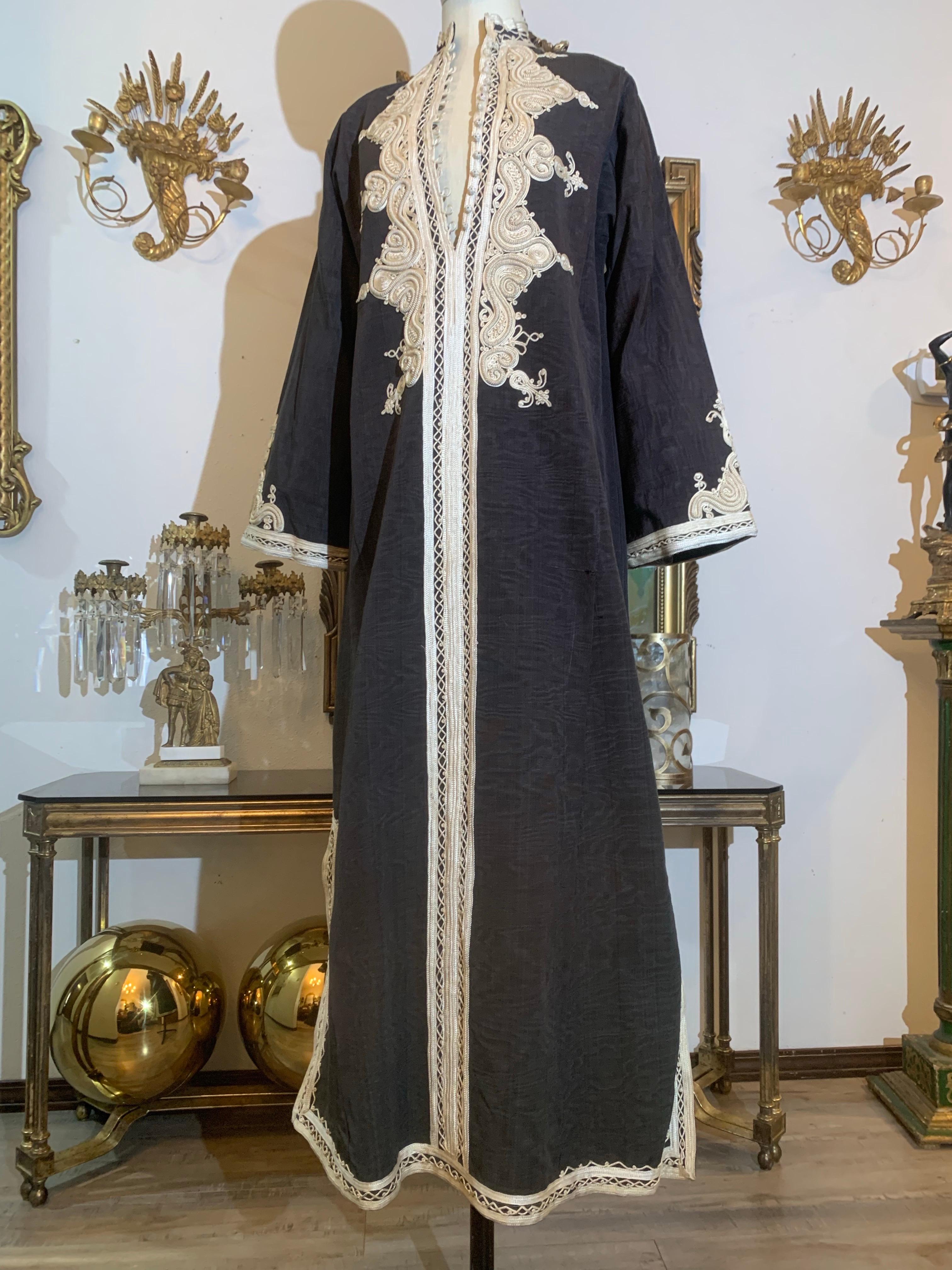Caftan marocain traditionnel en noir mat moiré avec un incroyable travail de tressage à l'encolure :  Il s'agit d'un fantastique caftan moiré de poids moyen avec un généreux tressage de coton ivoire et des boutons boules en corde avec des fermetures