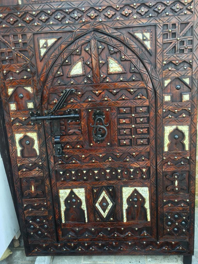 This heavy wood door was handmade in a family Cooperative in the southern Moroccan town of Zagora. Hand carved from the fragrant wood of the Tamarisk tree 100-200 years ago, this expertly crafted door has been refinished in the traditional ornate