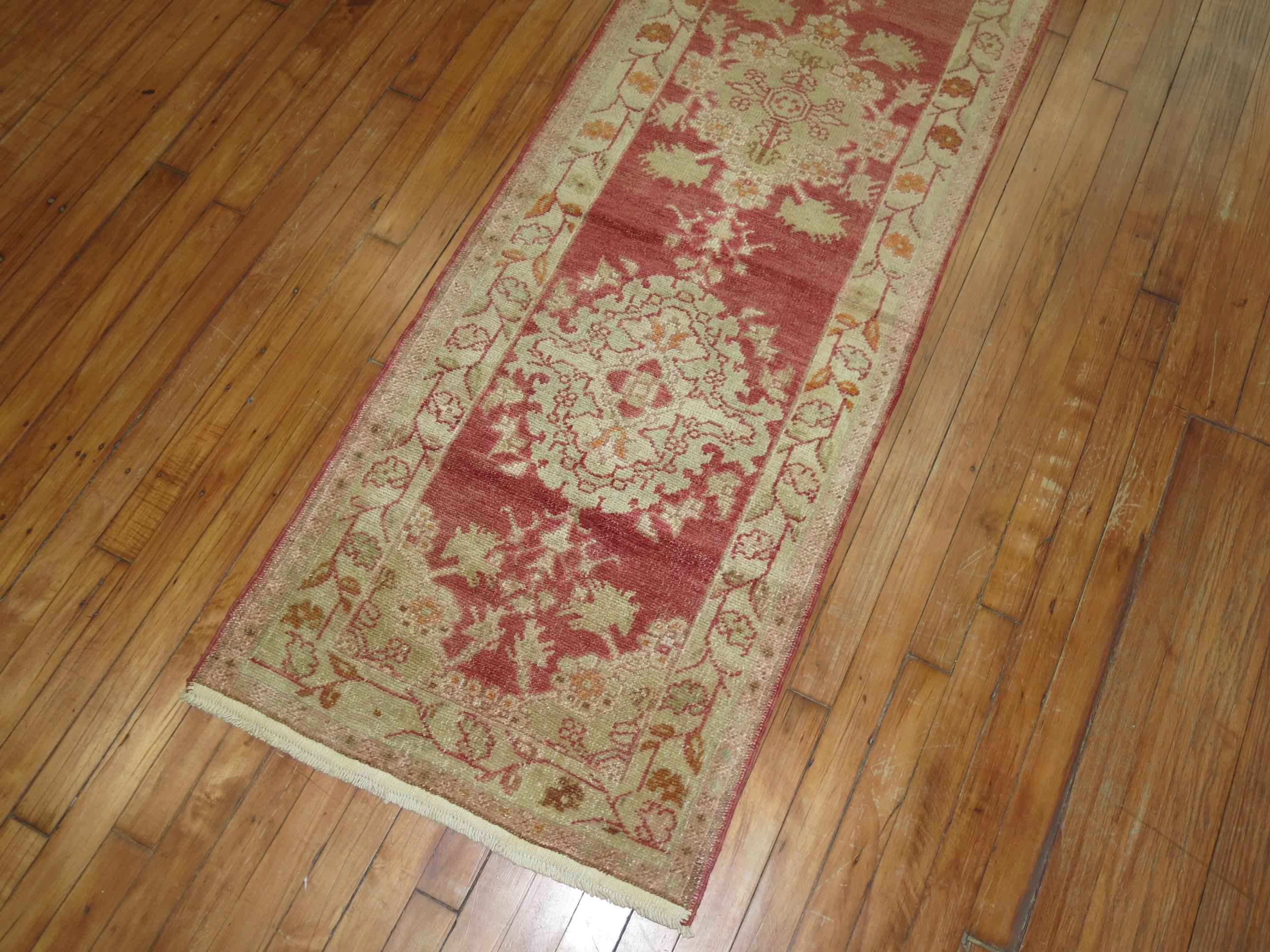 Mid-20th century red field Turkish runner with an all-over repetitive medallion design.

Measures: 2'1” x 11'9”.