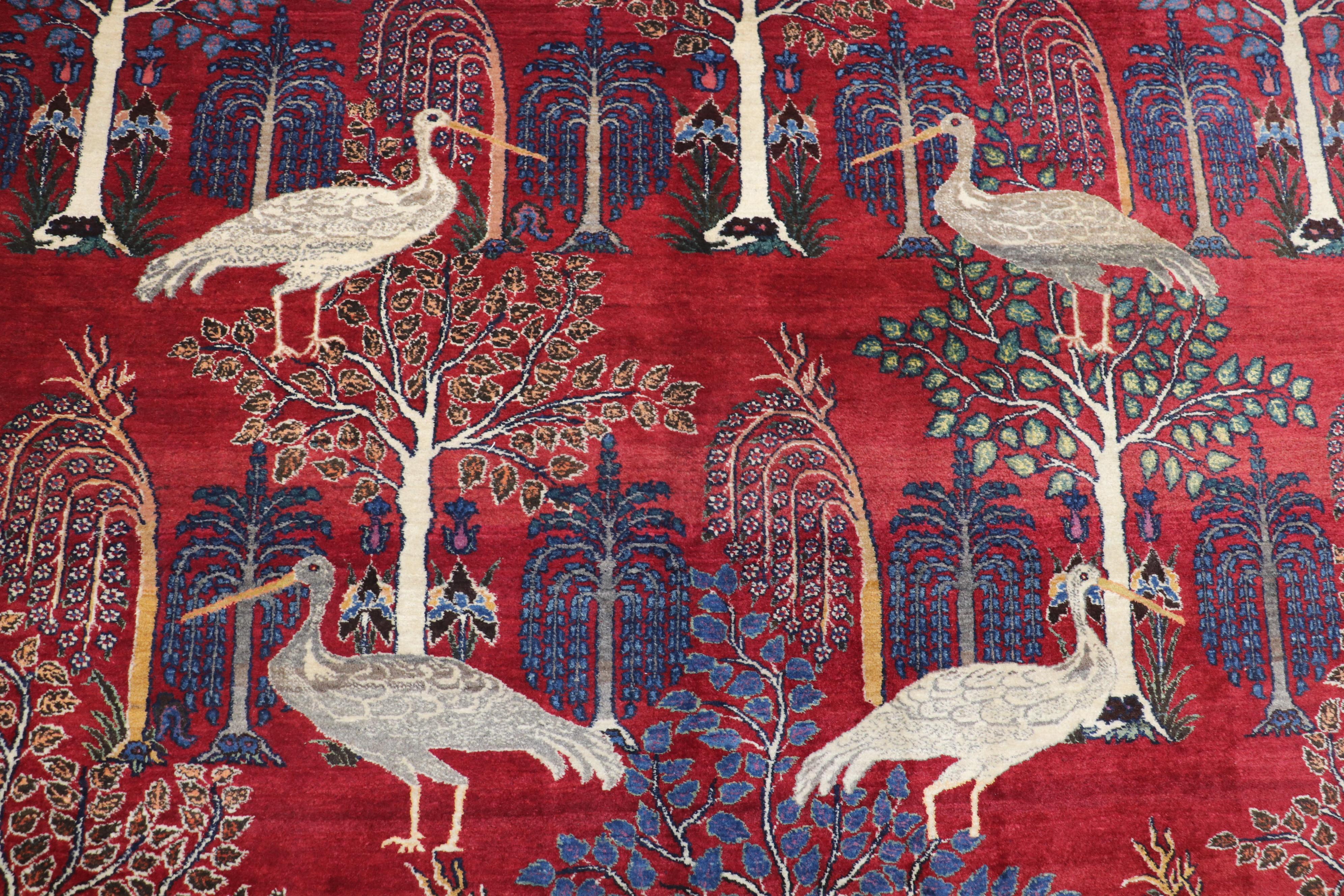 Beautiful Traditional Persian Tabriz oversize rug from the second quarter of the 20th century. In reds and blue with an all-over directional tree motif with 4 cranes on the center of the rug.

Measures: 12'2” x 17'10”.

 