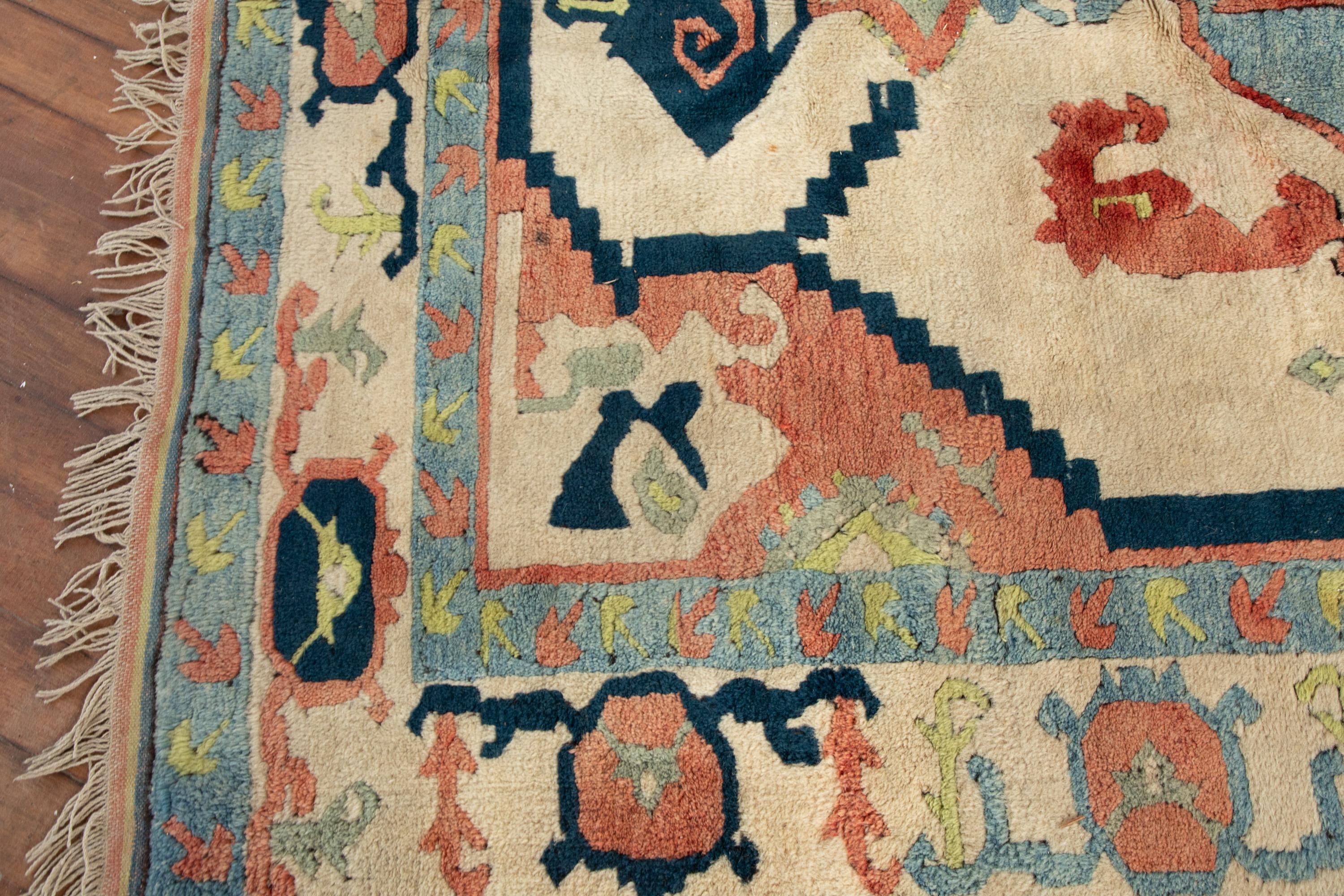 Traditioneller Oushak-Teppich.
Handgeknüpfter Wollteppich mit einem klassischen, farbenfrohen Muster.

Cremefarbener Hintergrund mit einem himmelblauen, marineblauen, lindgrünen und einem erdigen rosa/pfirsichfarbenen Muster. Aufmunternde