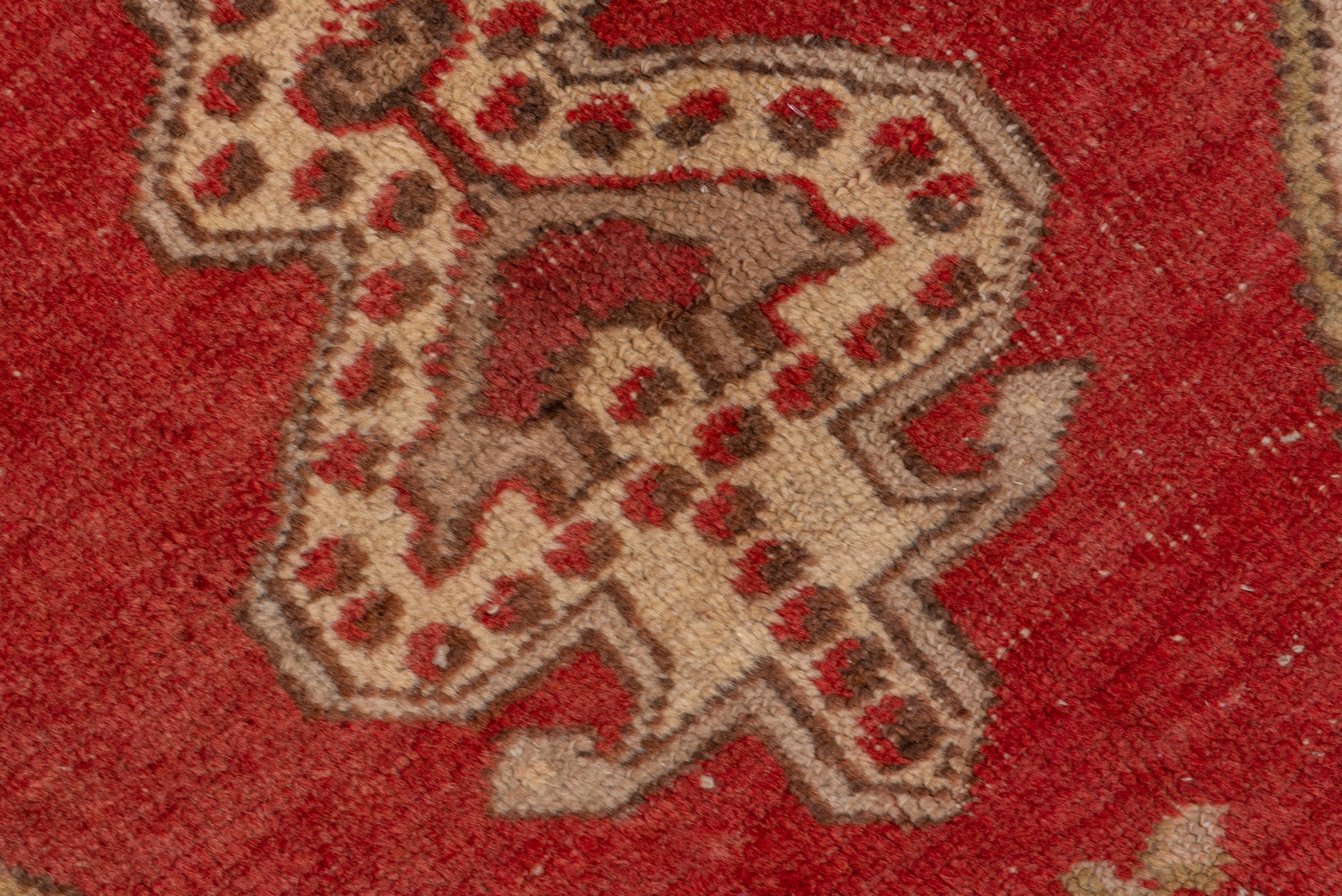Ein 12-zackiges Strohmedaillon mit einem Blatt in der Mitte und gepunkteten Anhängern ist auf den weichen roten Grund mit sandfarbenen Ecken gesetzt und von einer rotbraunen, schmalen Sternbordüre eingerahmt. 

 