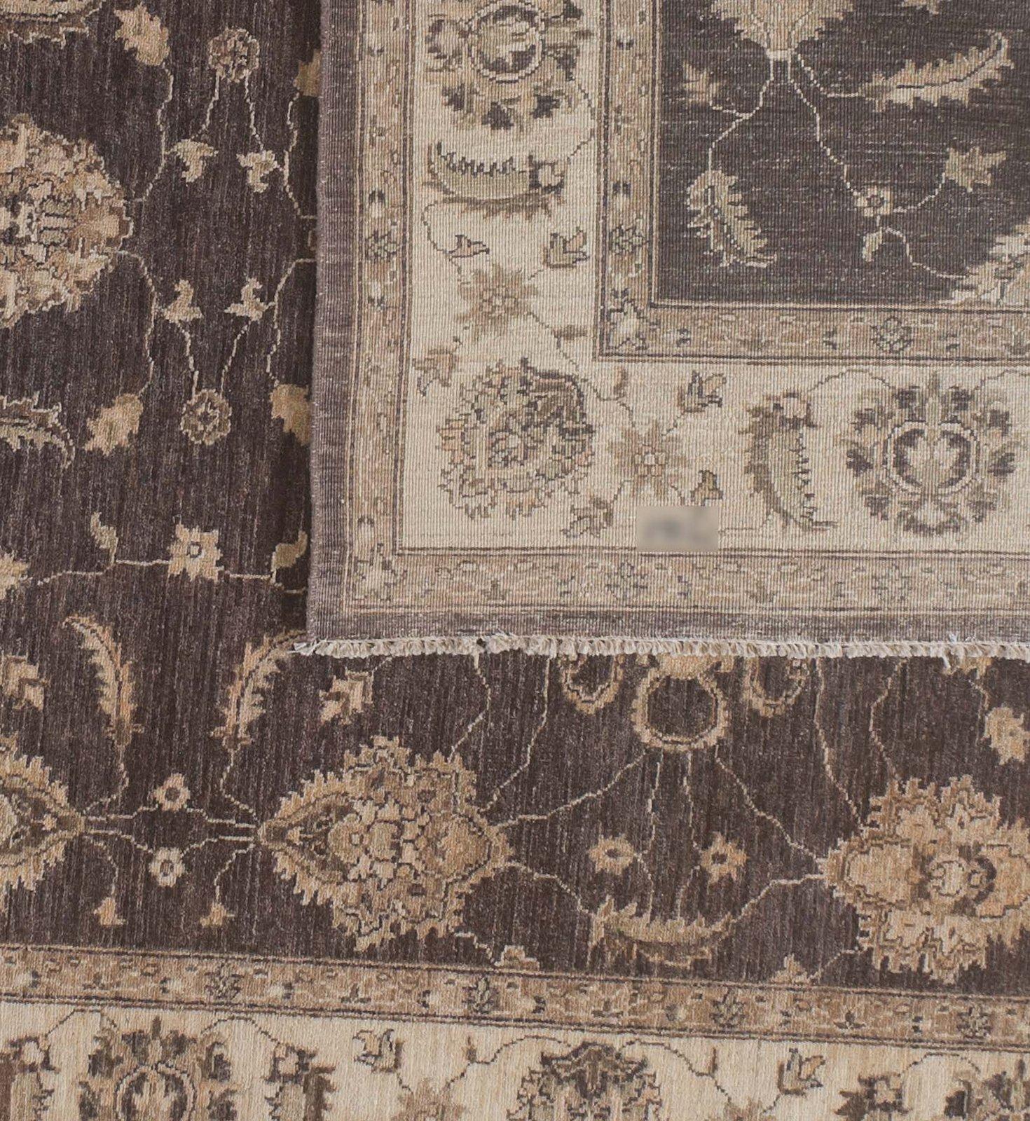 Striations of light and dark brown tones that reveal themselves in subtle variations depending on light and angle are the hallmark of this traditional Pakistani wool area rug. The contrasting dark core and cream border generate a feeling of grace