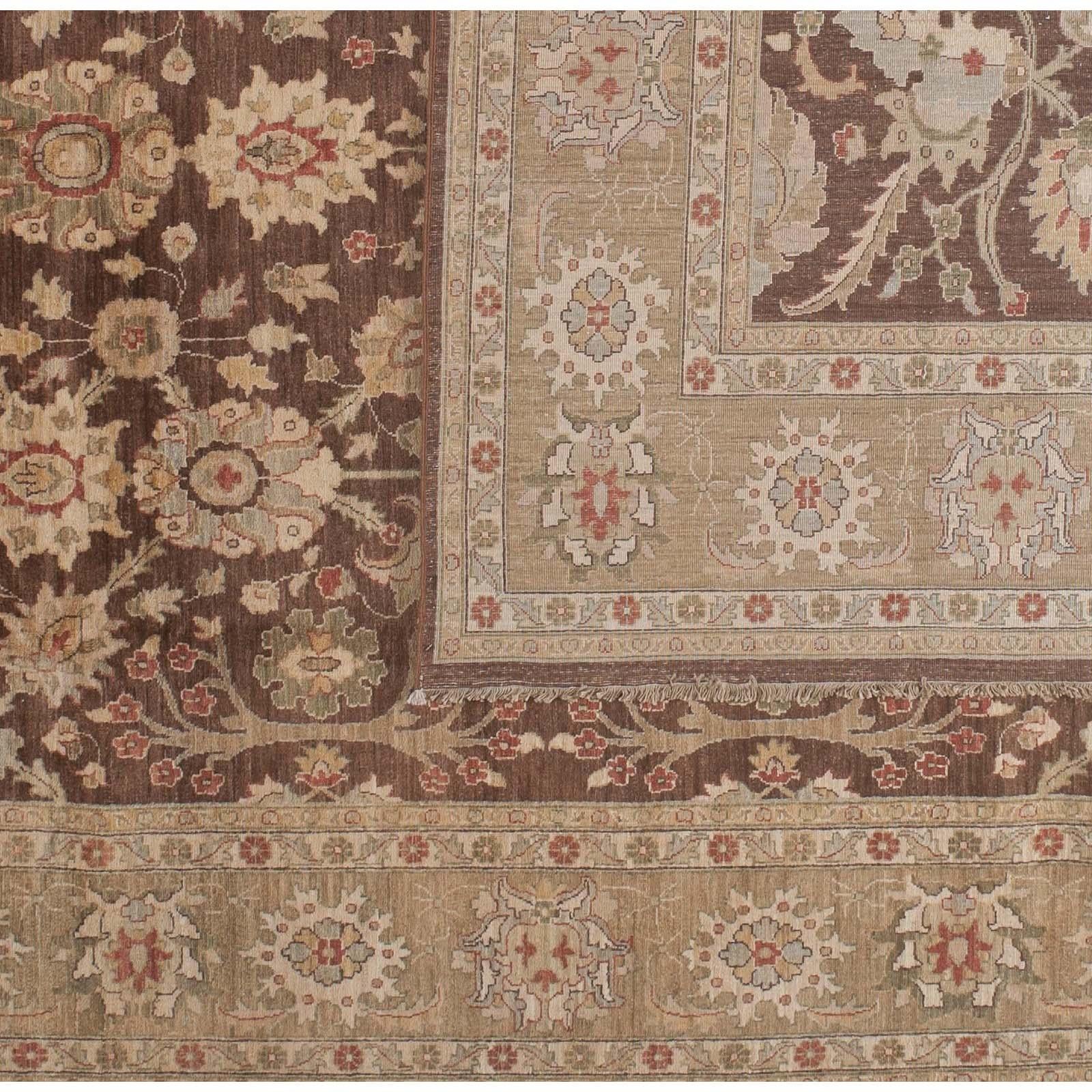 A bold brown center with floral design surrounded by a wide beige border creates an elegant and finely balanced piece. Wool. Hand knotted in Pakistan using vegetal dyes.
