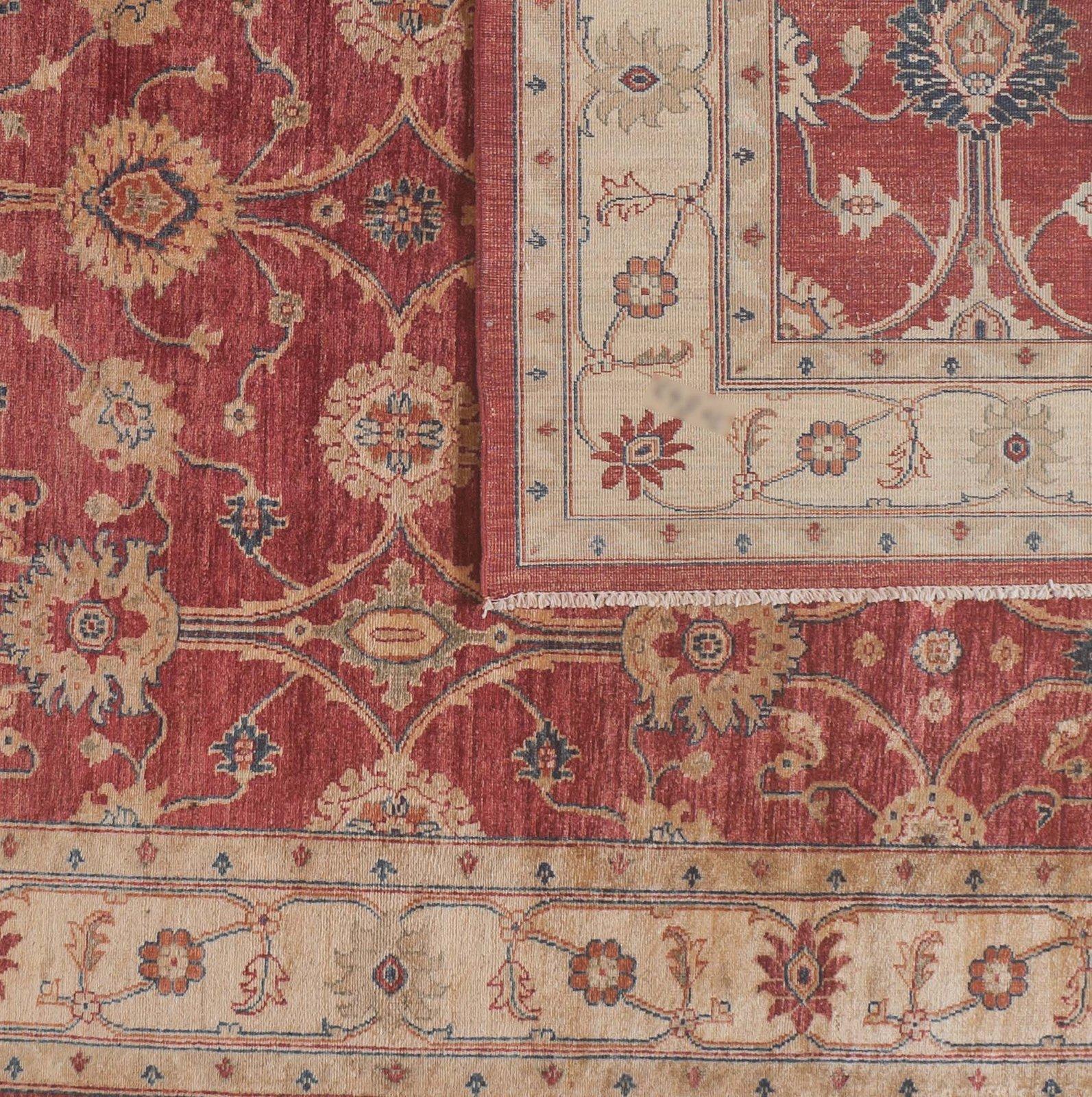 Tealfarbene Linien und Blätter verleihen diesem traditionellen pakistanischen Blumenteppich in Rot und Beige ein unverwechselbares Farbelement. Wolle. Handgeknüpft in Pakistan unter Verwendung pflanzlicher Farbstoffe.