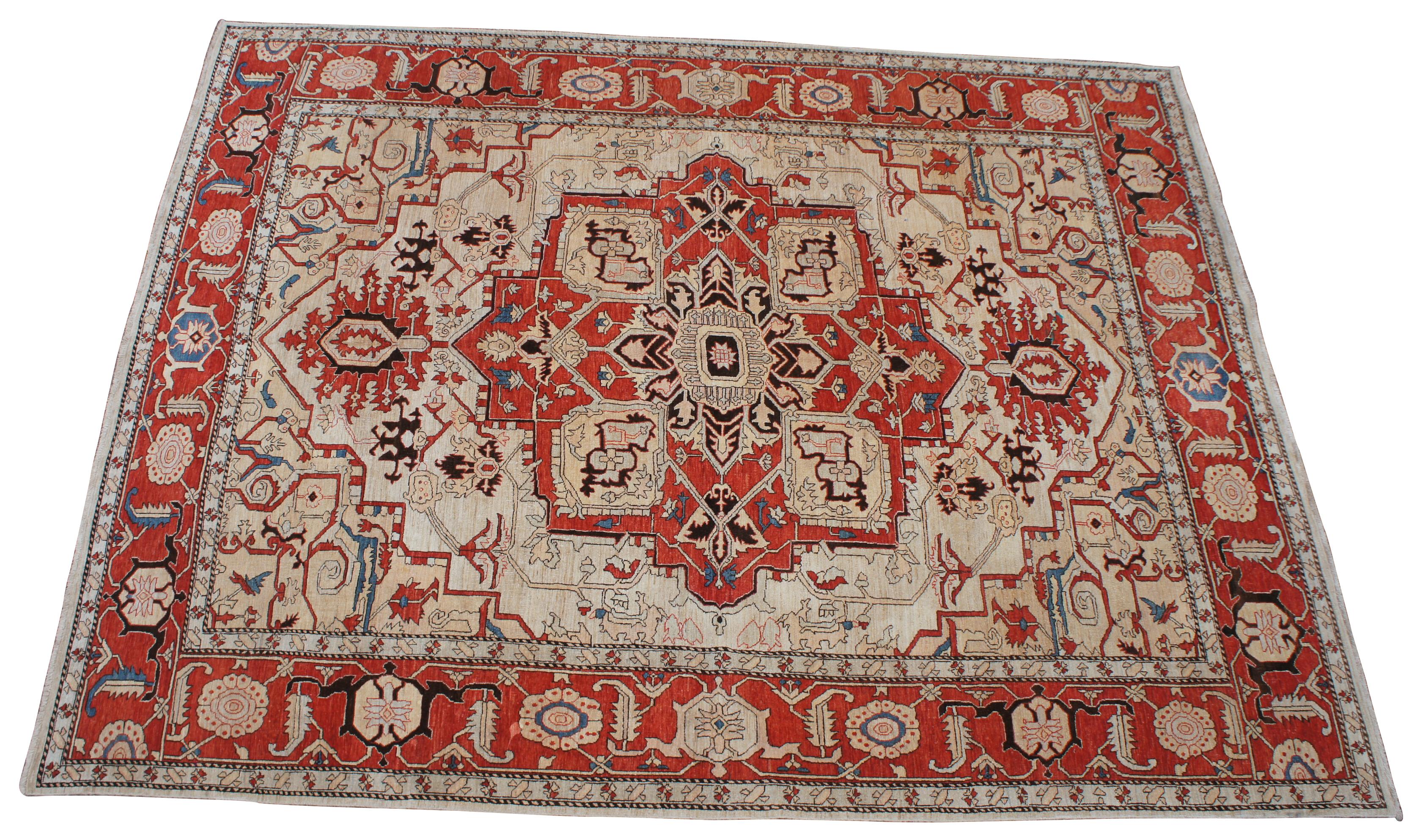 Vintage Persia revisited Heriz area rug carpet. Features a field of tan / ivory / beige with a central medallion and floral motif with reds, blues and black accents. Constructed of 100% hand spun wool and 100% handmade natural dyes. Made in northern