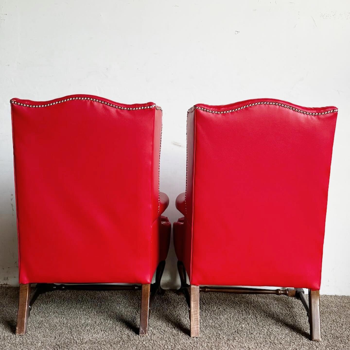 Die Traditional Red Faux Leather Wingback Chairs, die als Paar erhältlich sind, bringen zeitlose Eleganz in Ihre Einrichtung. Mit ihrer klassischen Silhouette bieten diese Stühle Stil und Komfort. Der satte rote Kunstlederbezug sorgt für Raffinesse