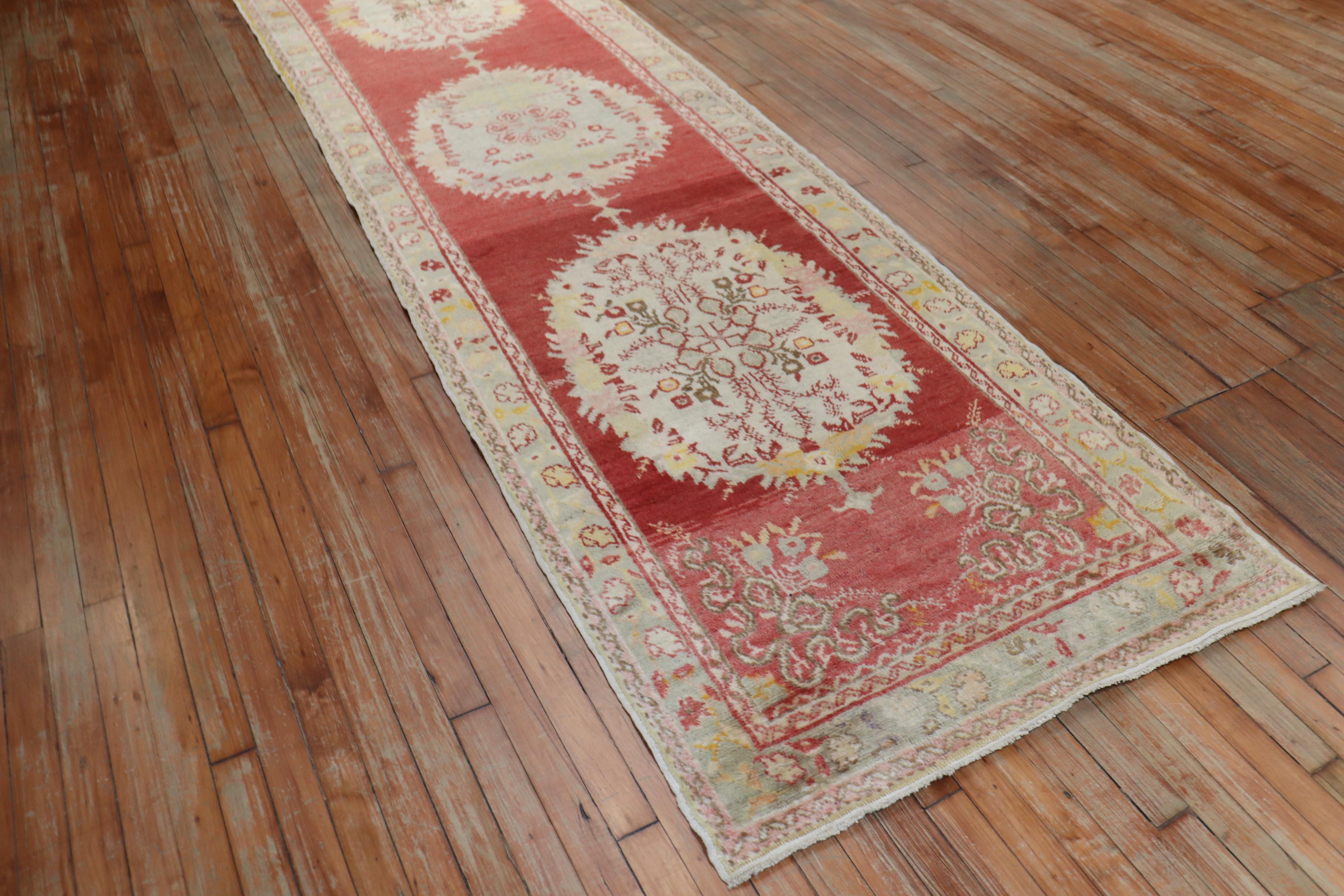 An affordable one-of-a-kind Turkish Oushak runner with center medallions running on a red field

Measures: 3'3” x 12'2”.