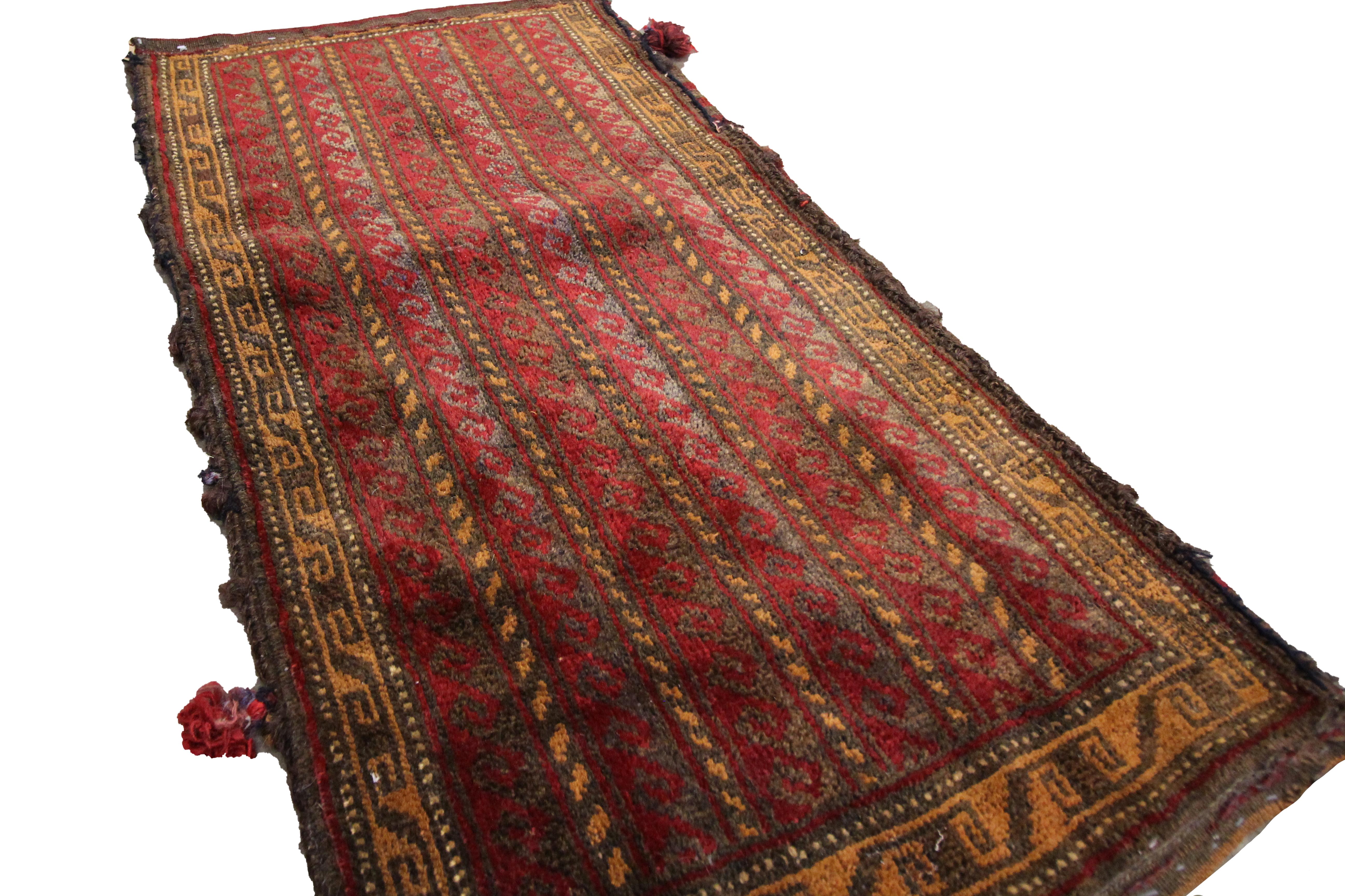 This bold wool rug is an antique Chuval Rug woven by hand in 1910. The design features a traditional stripe design with hook details woven in red and brown. The symmetrical geometric design and bold colour palette make this piece the perfect accent