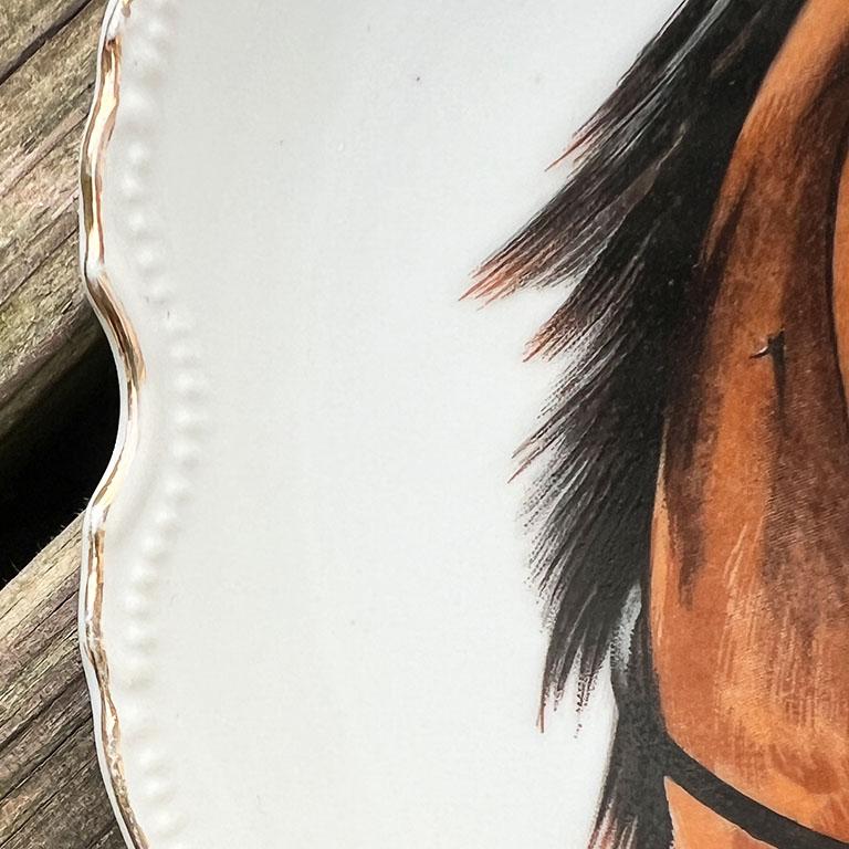 A timeless round ceramic decorative horse plate. This piece will be wonderful hanging on a wall, or used as a catchall or trinket dish on a coffee table. It has scalloped gold edges with a textured dot pattern surrounding the rim. At the center, is