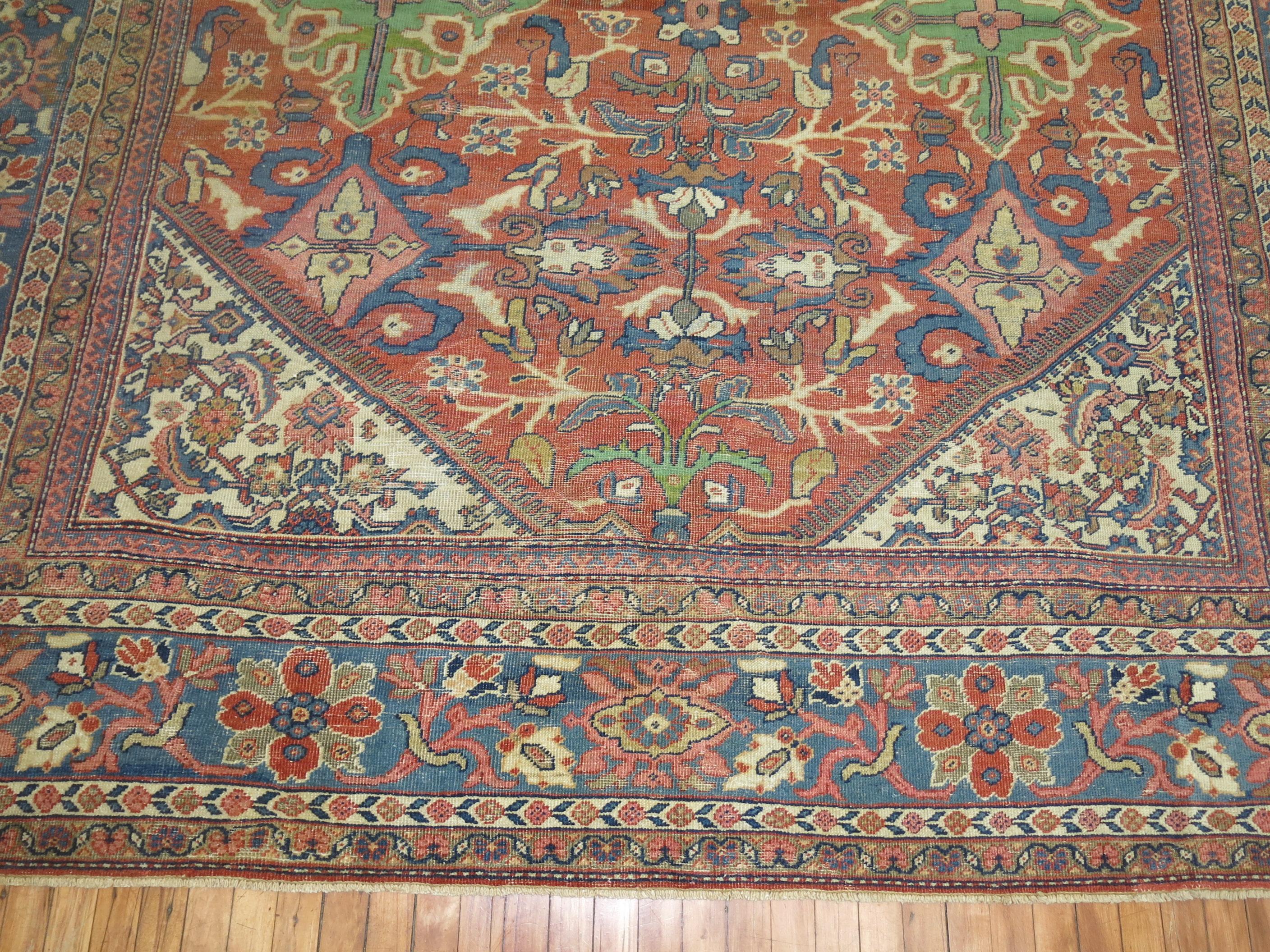 Room size early 20th century antique Persian Mahal rug with an all-over large scale geometric design a rust red field light blue border. Dominant accents in green and pink

Measures: 9'2” x 12'10