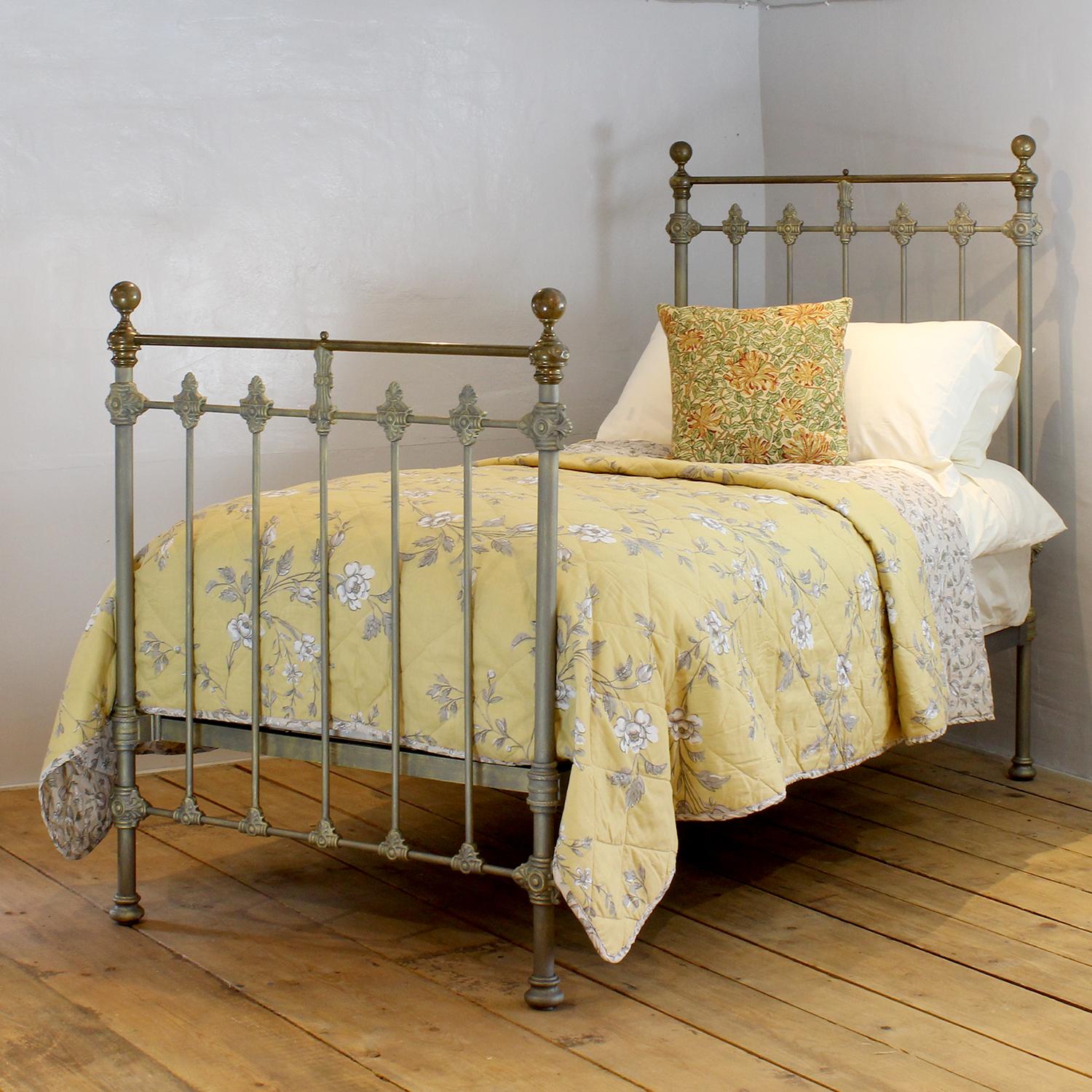 A traditional single Victorian brass and iron antique bed in hand-painted faded gold, with tarnished brass top rail, brass collars and round knobs.
This fine original antique bed from the late Victorian era has attractive castings, which have been