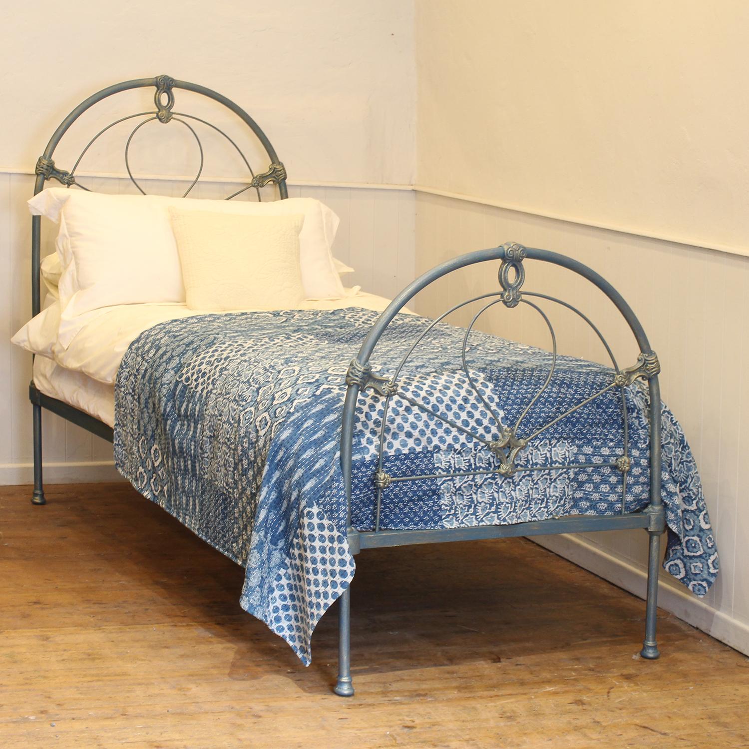 A traditional single Victorian cast iron antique bed in blue and gold and arch design.
This fine original antique bed from the late Victorian era has attractive castings, which have been accentuated by the hand-paint finish. 
This bed takes a