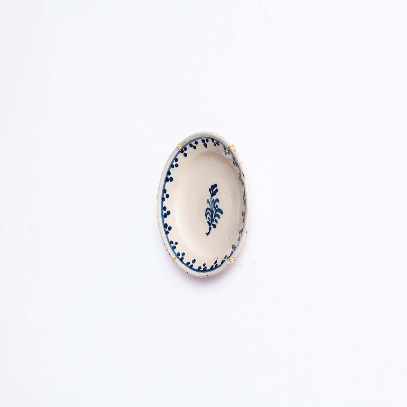 Keramischer handbemalter Teller eines unbekannten Künstlers.

Dieser atemberaubende Keramikteller, der sorgfältig von Hand in einem ruhigen Blauton auf einem makellosen weißen Hintergrund bemalt wurde, wertet Ihre Einrichtung auf. Jeder Pinselstrich