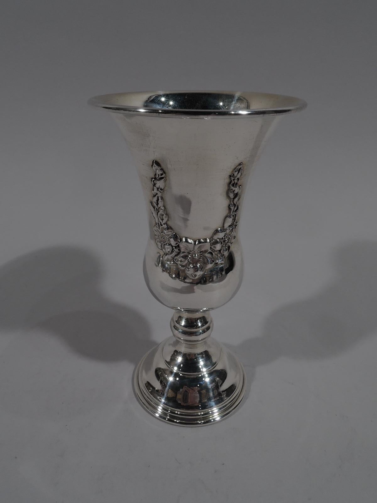 Traditional sterling silver Kiddush cup. Tapering with gently bellied bowl; knopped stem and domed foot. Applied ornament: Star of David on front, and floral garlands on front and back. Marked “Sterling”. Weight: 2.4 troy ounces.